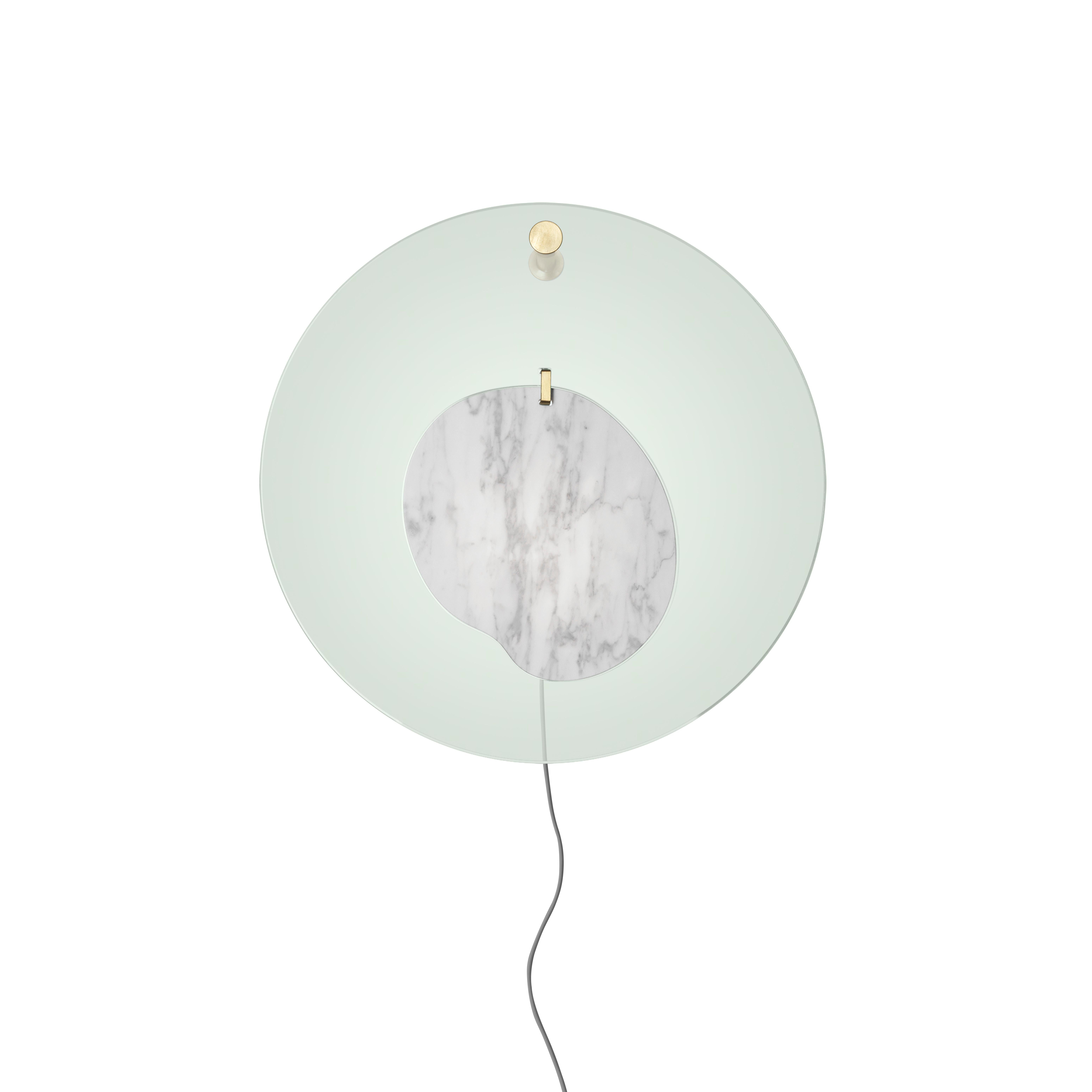 Gioia is a jewel created to adorn domestic space. The magic of the lamp lies in its composition: an element in statuary marble placed at the centre of a transparent disk. The two parts are free to move, as in the swaying rhythm of a pendant or an