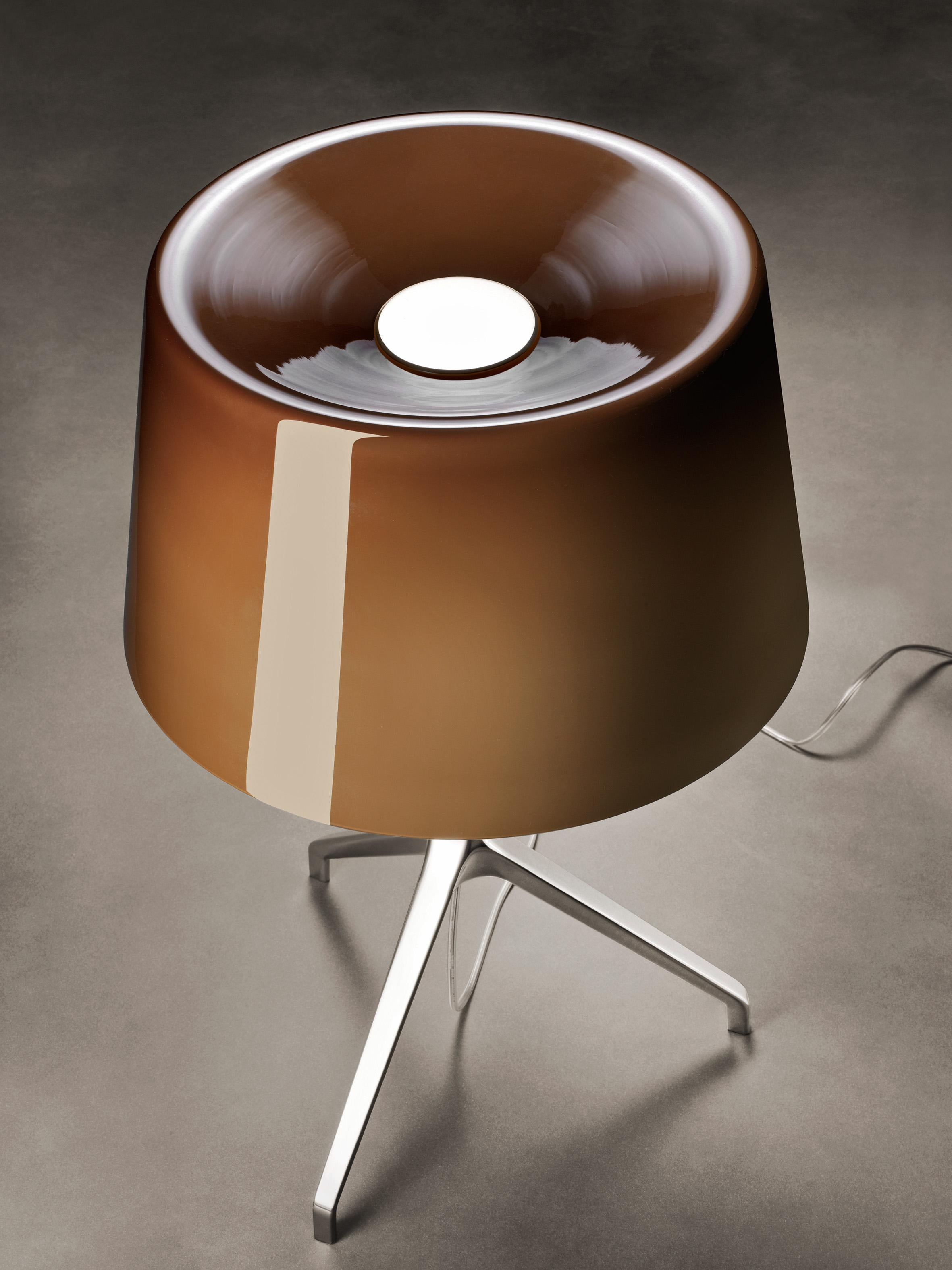 Lámpara de sobremesa de luz directa y difusa. Difusor de vidrio soplado a mano con acabado brillante, blanco por dentro y coloreado por fuera. Base y varilla de aluminio fundido a presión, acabadas y pulidas a mano en la versión de aluminio,