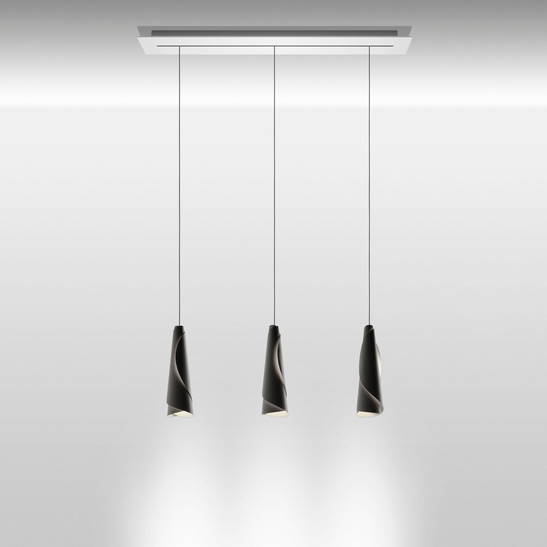 Suspension lamp with direct light. Diffuser consisting of two laser-cut aluminum sheets, which are rolled up and slipped into one another. The engravings on the diffusers let the light out, to delineate the contours of the two sheets with a glow of