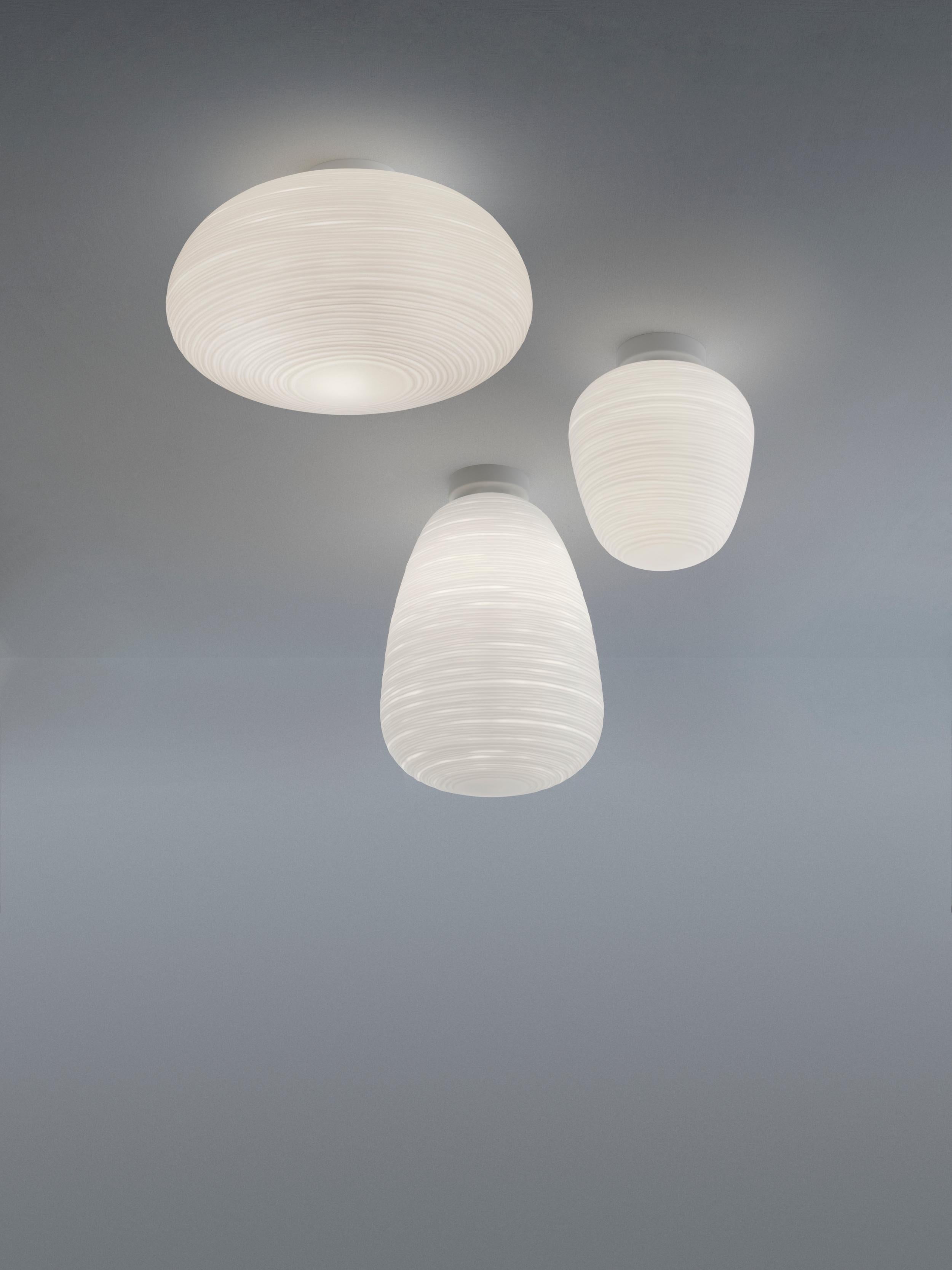 The Rituals ceiling lamps translate the luminous magic of oriental rice paper lanterns into items of contemporary design, made of blown glass with a special processing on the surface. Distinguished by an elongate shape, Rituals 1 diffuses a