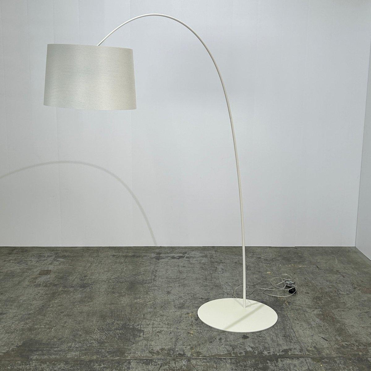 Introducing the stunning Twiggy Floor Lamp by Foscarini, a true statement piece for any modern home. This iconic lamp features a slender stem topped with a large fabric shade that creates a warm and inviting glow. The unique design of the Twiggy