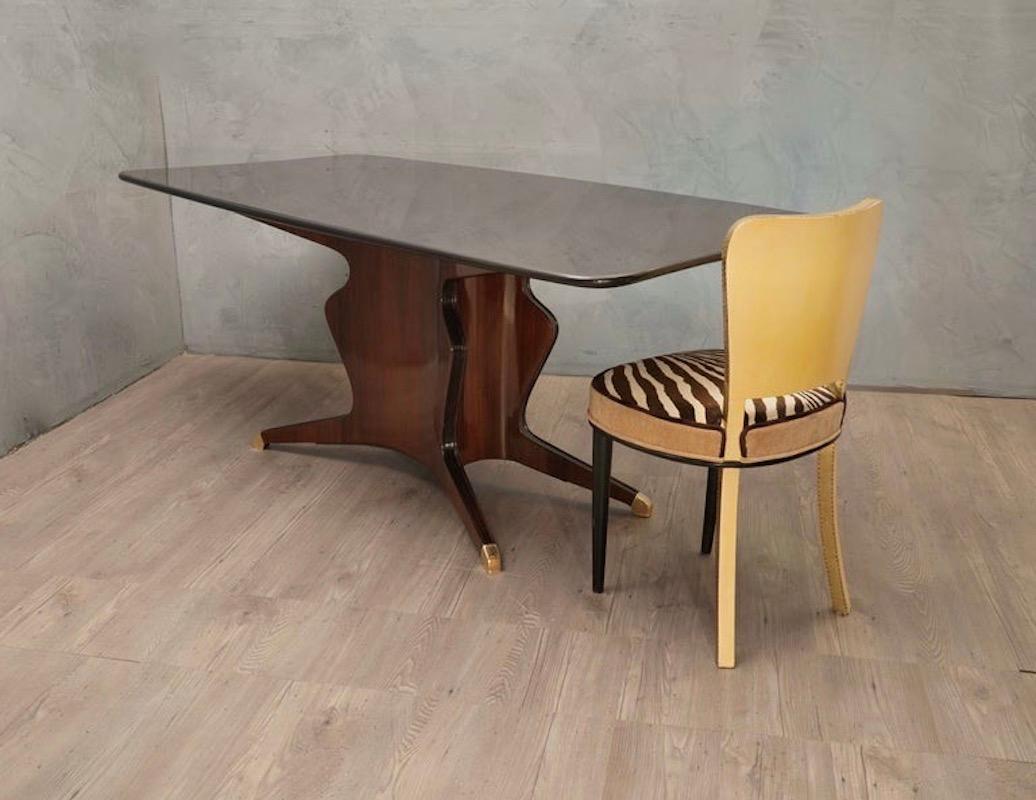 Surprising and still contemporary design for the time, if you consider that it is a table from the early 1950s; still very original and unique in its style. Clean and simple design.

The structure of the wooden top is shaped and polished with black