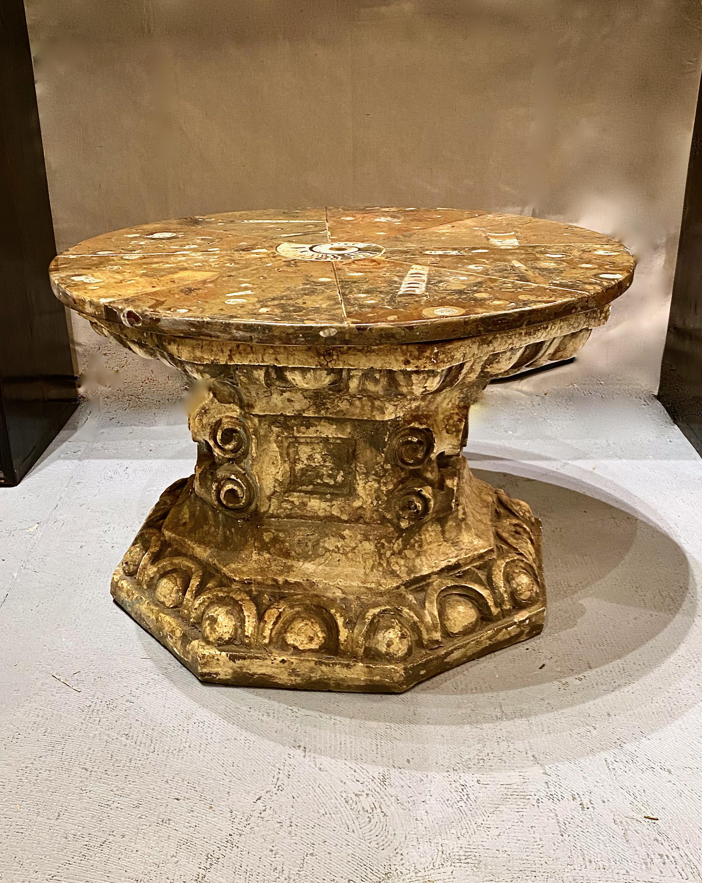 This uniquely created table could easily have been inspired by the the aesthetics of Tony Duquette. The neoclassical heavy cast plaster plinth is eight-side and detailed in an egg-and-dart design, and well as in cast scrolls. Additionally, the