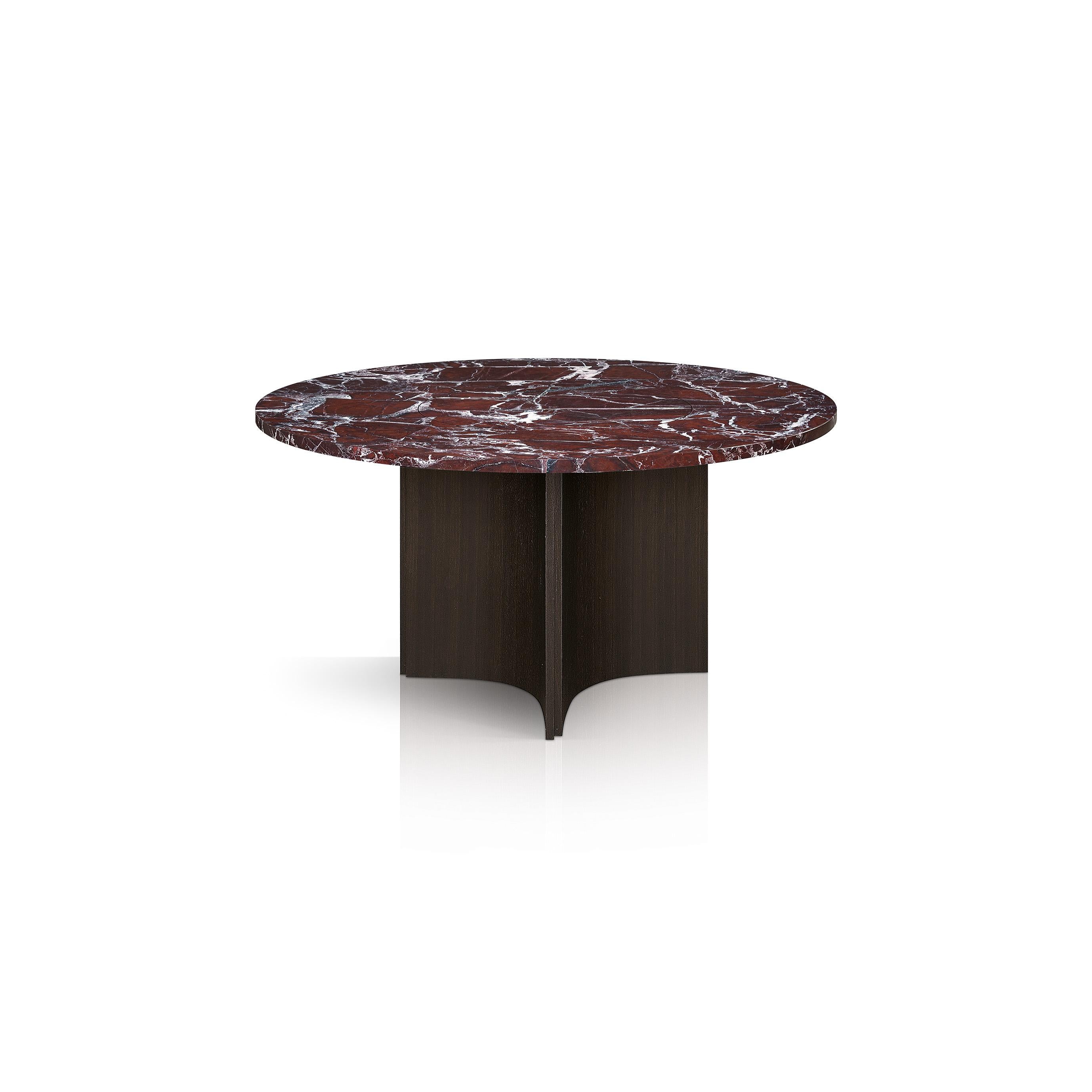 Au centre d'une salle à manger moderne et contemporaine, cette table est dotée d'un remarquable plateau en marbre rouge vin de Steele reposant sur un piètement de style colonne en acier plaqué de chêne. Faisant partie de la Collection Fossil de