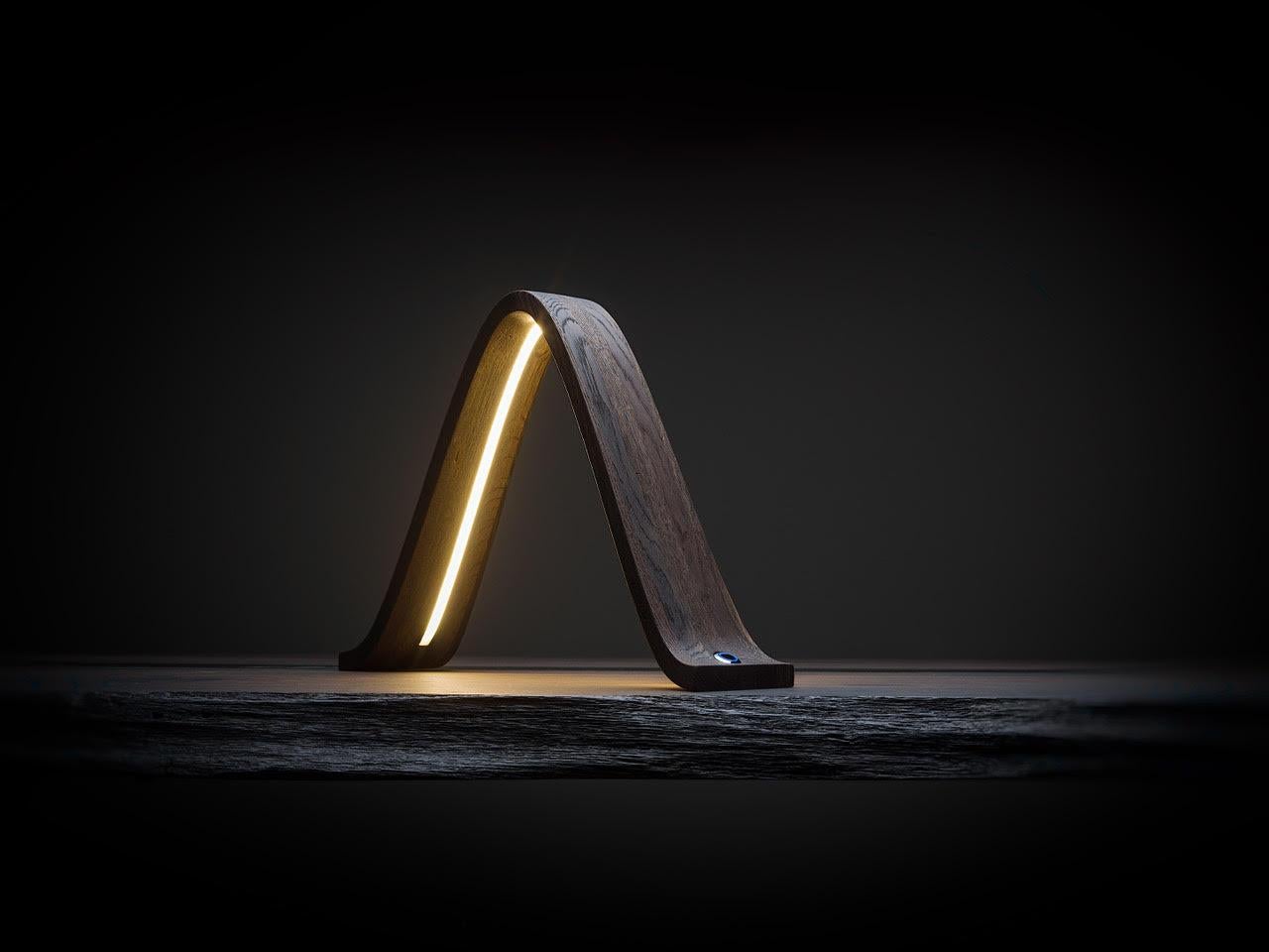 Small masterpiece of wood engineering, this lamp with sober and essential lines gives bright emotions in every corner of the rooms. The contrast of fossil wood with the diffused light of the dimmable LED line, with its elegant touch switch, creates