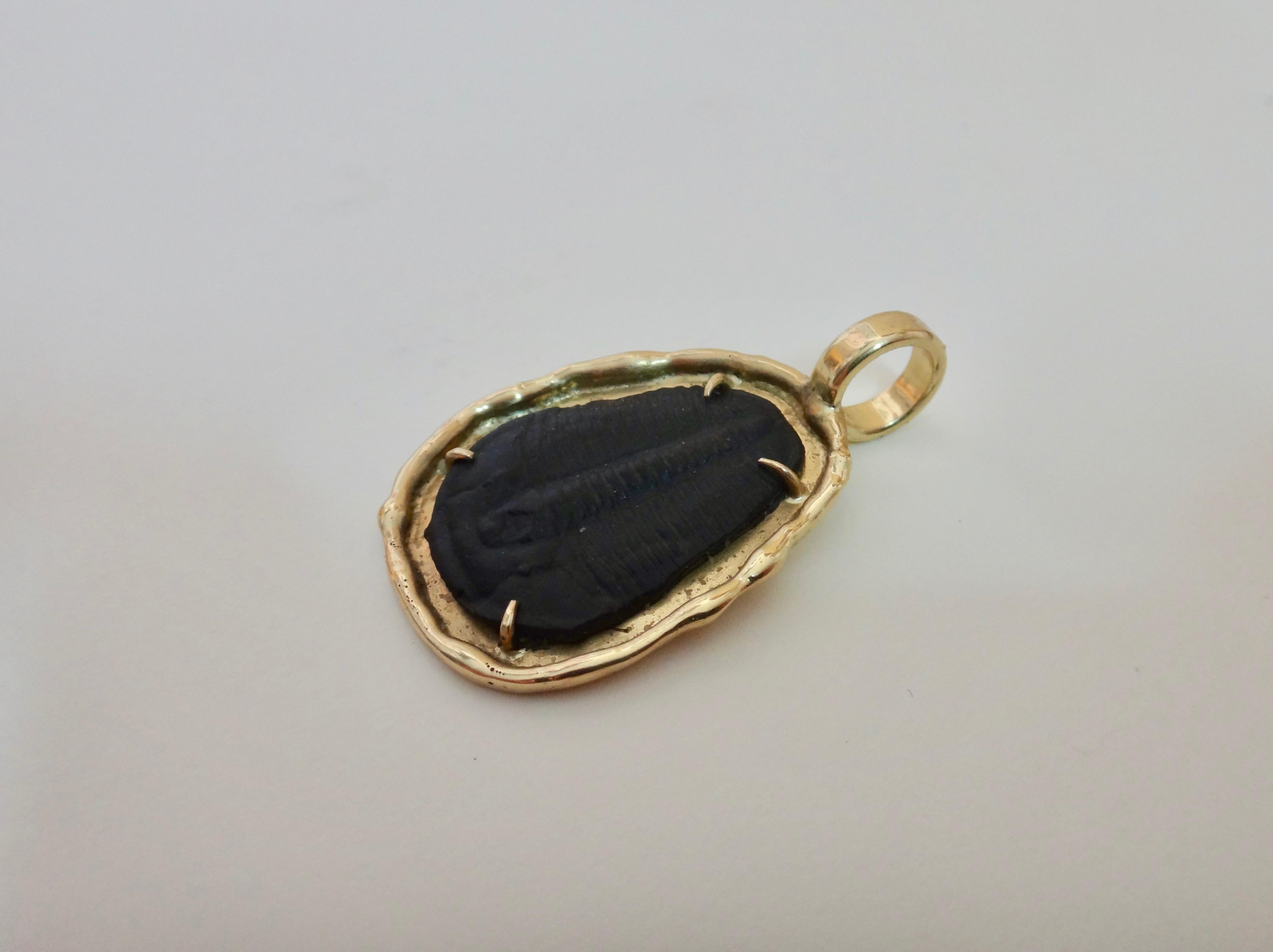 An excellent example of a fossilized trilobite is featured in this one-of-a-kind, 18k yellow gold pendant.  Trilobites are a group of extinct archnomorph arthropods that form the class Trilbita.  Trilobites are one of the earliest-known groups of