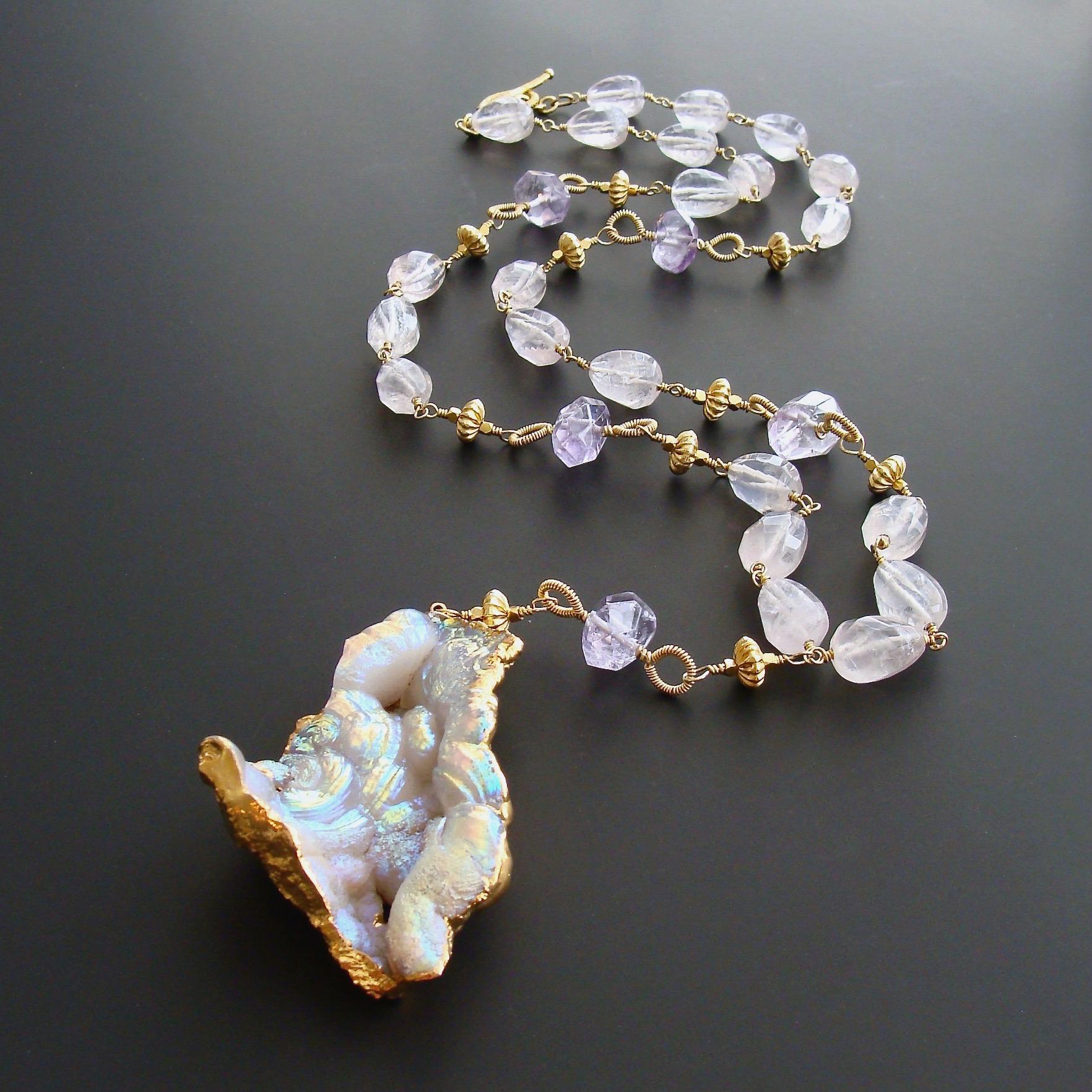 An irresistible specimen of opalescent fossilized Aura Coral - with flashes of soft violet, pink and blue - renders this otherwise traditional necklace into the realm of a wild and organic beauty.  The swirly and earthy shape of the pendant have