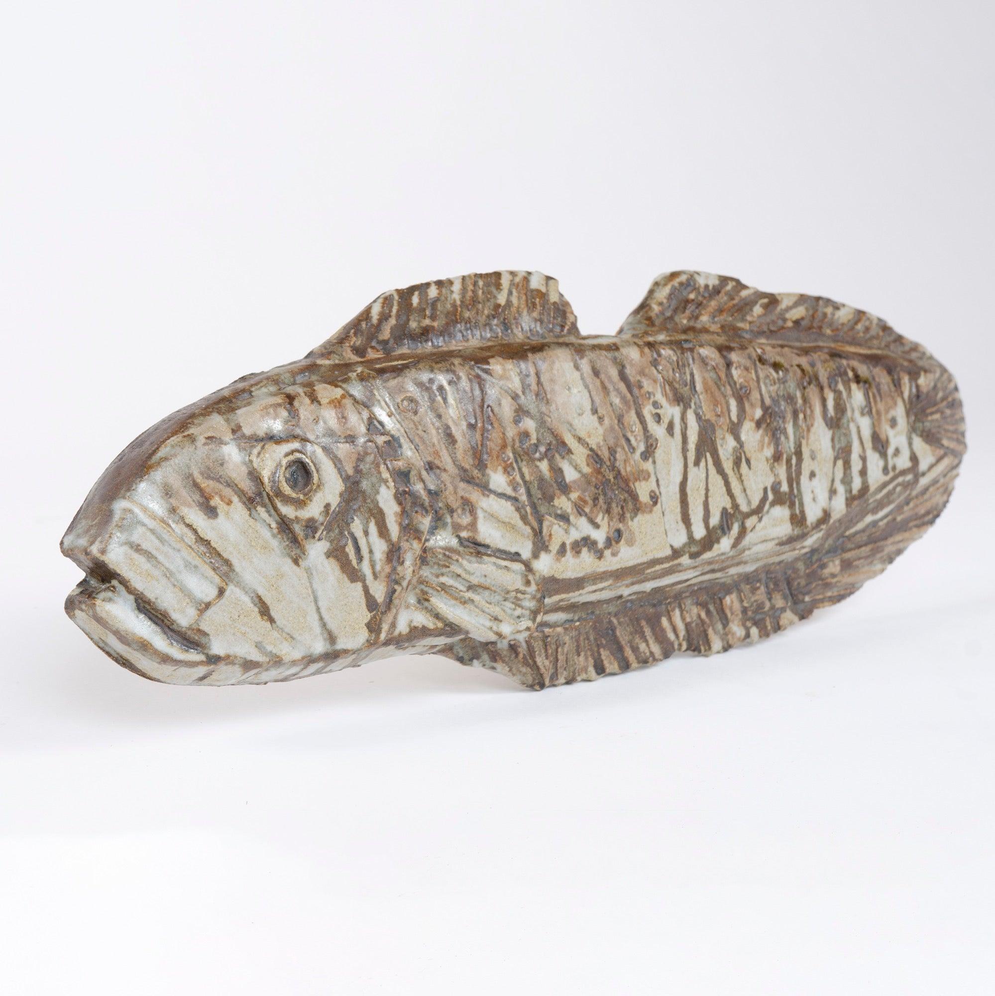 Un'impressionante scultura in gres di un pesce fossile con uno smalto opaco ricco e variegato su impressioni testuali espressive arricchite da marcature marroni sottosmalto. Firmato.