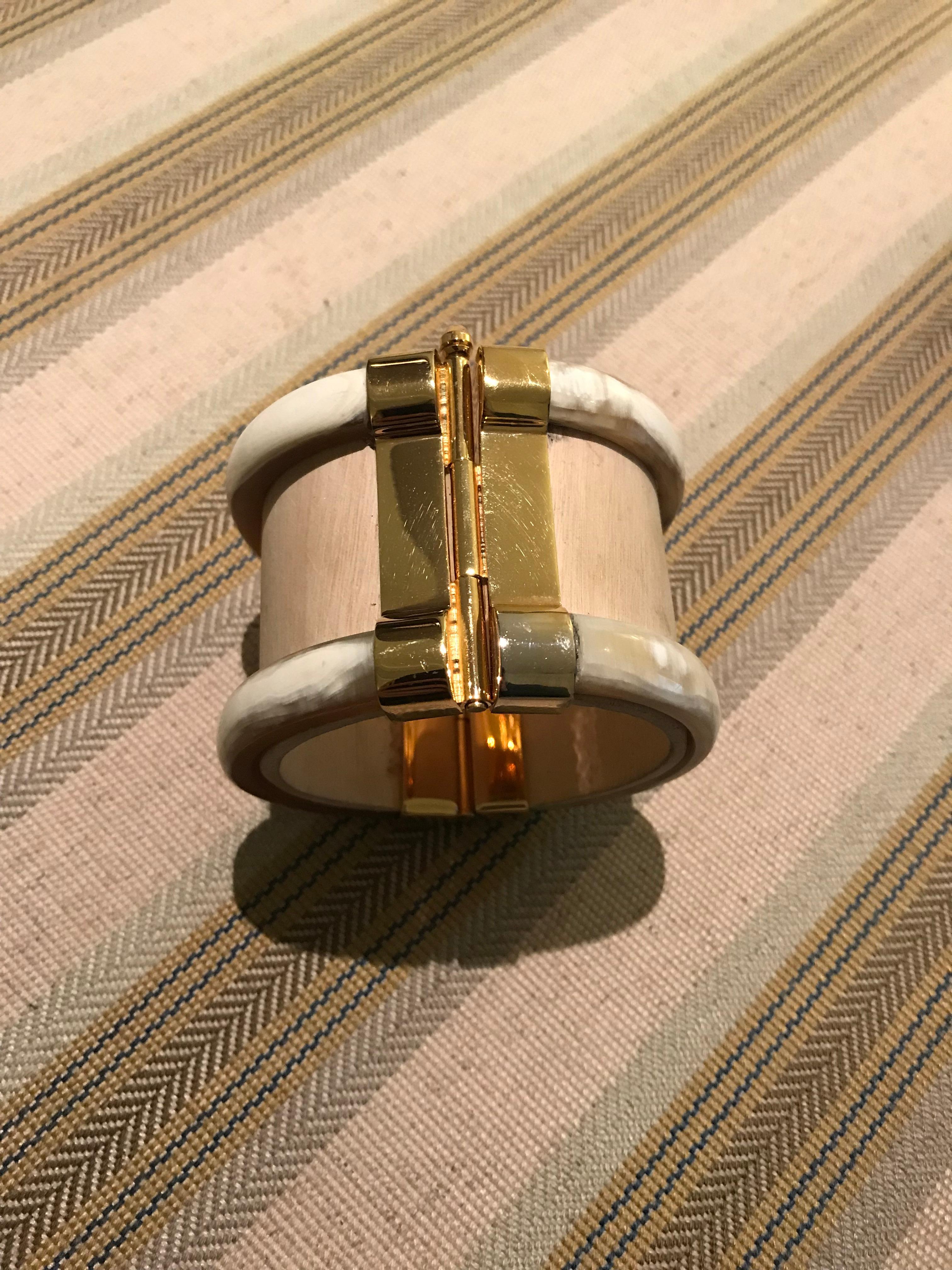 Cuff bracelet crafted from jacaranda wood and African cow horn. The 18k gold plate pin-clasp is set with fire opal from Ethiopia. 

Made in London from natural materials crafted by artisans in Kenya. Please note that horn graining and slight