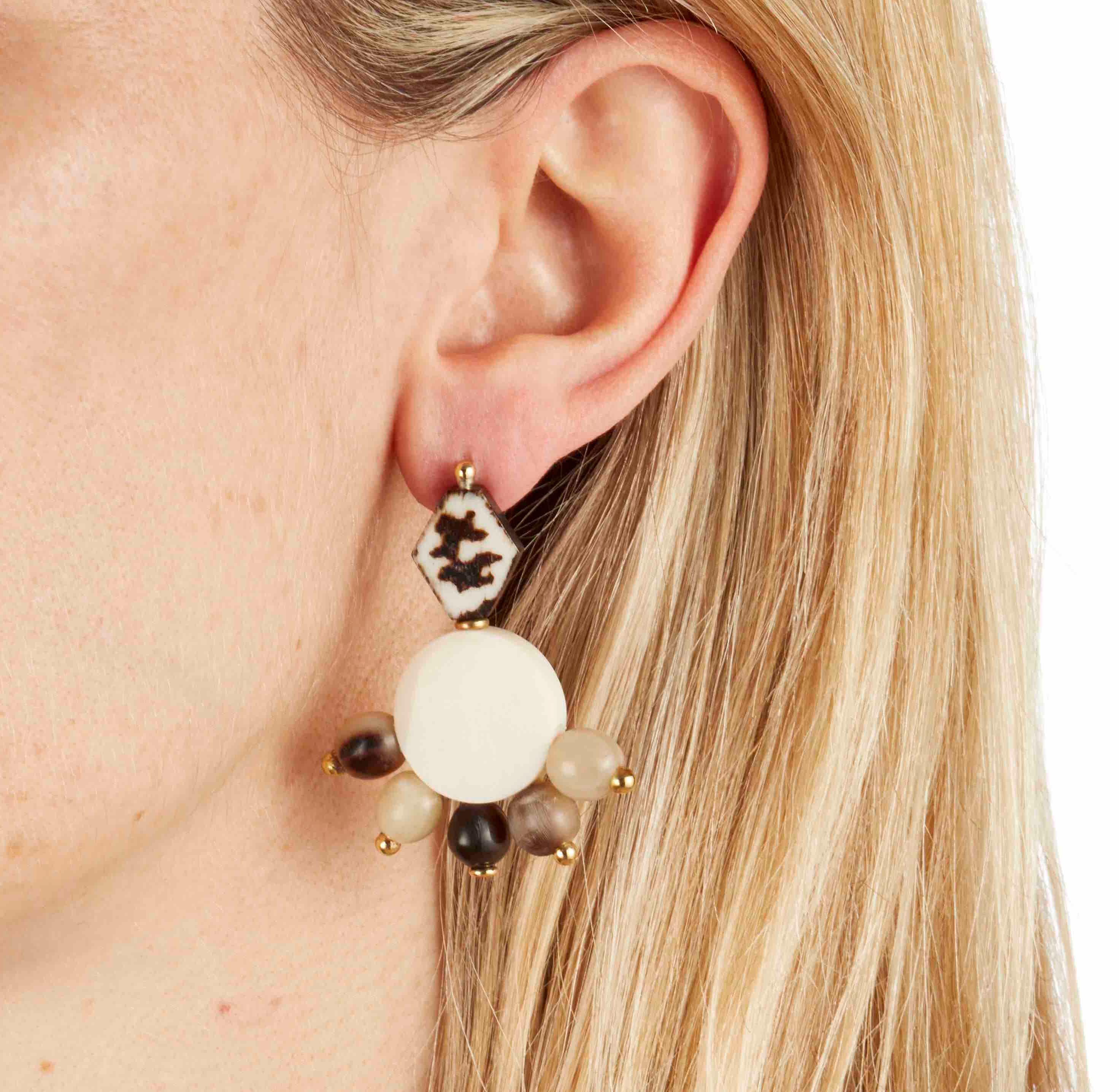 The finest carved African camel bone and cow horn beaded earrings; handmade in London using solid brass with solid silver pin-backs. 

The tops of these earring feature a batik design process ancient to Kenyan tribes.