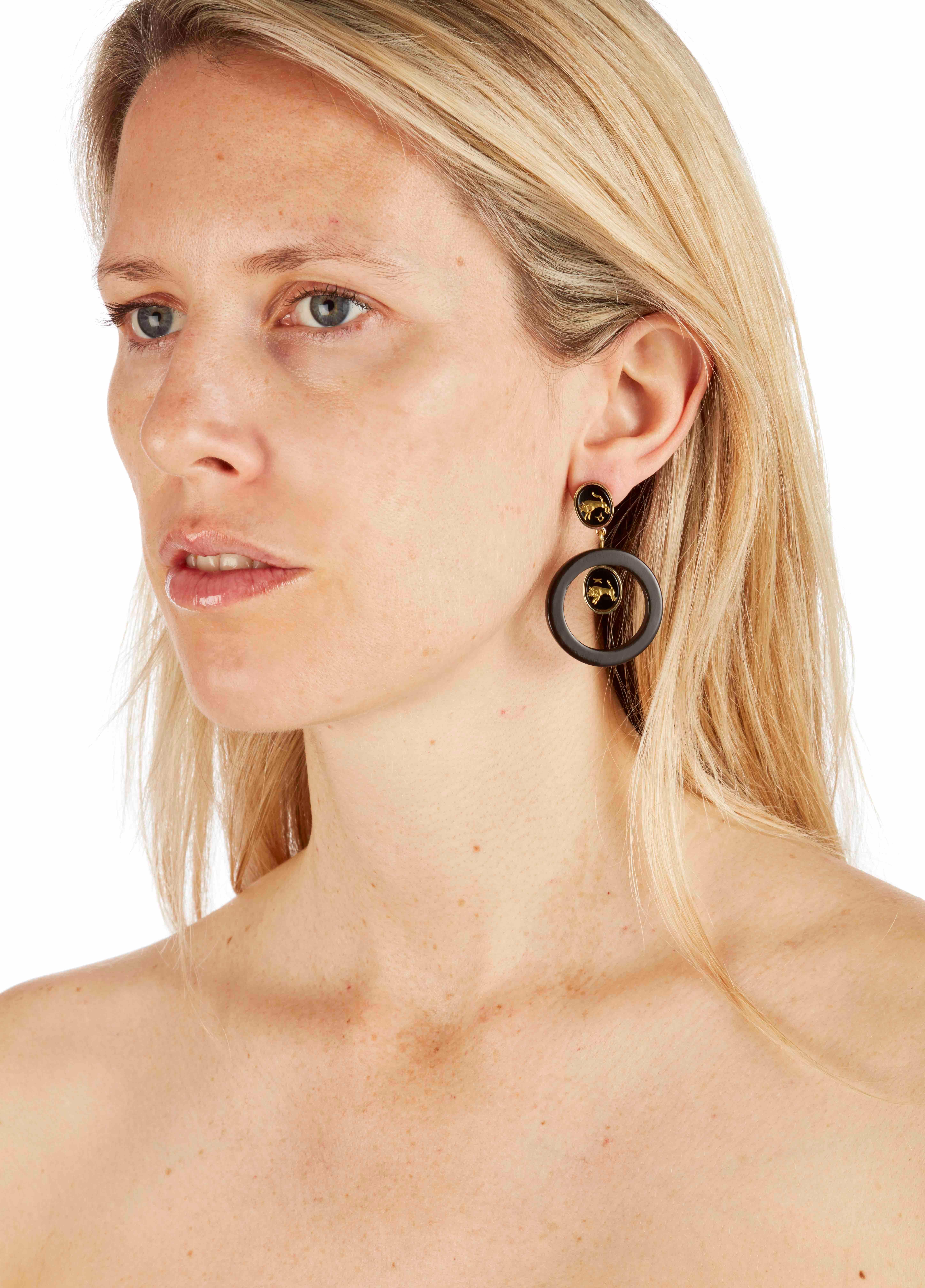 Carved onyx and African cow horn hoop earrings. 

The precious onyx stones feature engraved gold bulls reminiscent of ancient cave paintings found in the Koro Hills of East Africa. 

The cow horn is hand carved by artisans in Nairobi, Kenya and