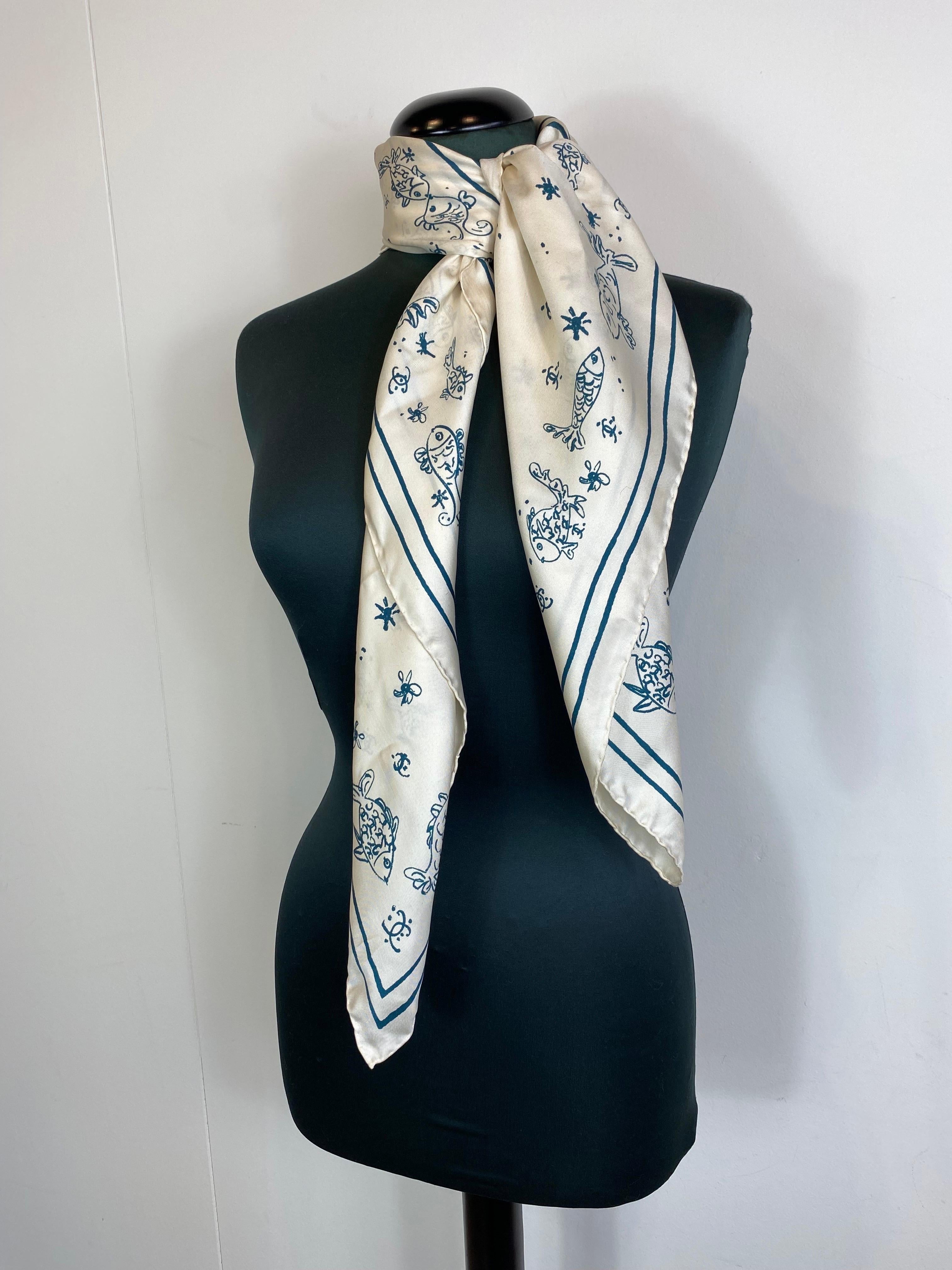 Chanel scarf in 100% silk. 
Ecru and dark green, patterned with fish.
Cruise 2024/2025.
Currently on sale on the site. 
New without a tag. 

90 cm x 90 cm 