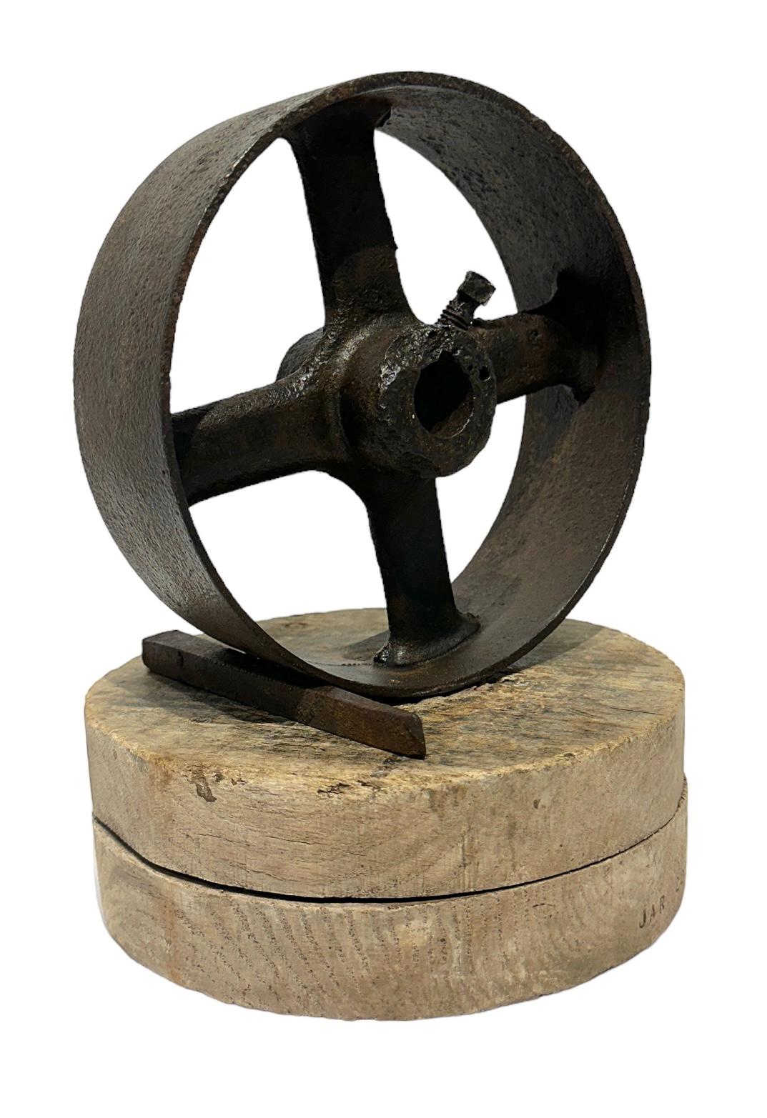 Jim Rose, known primarily for his steel furniture, was an avid collector and scoured salvage yards for unique, interesting items.  Here, a beautifully rusted wheel and a small wedge sit together atop a salvaged round wooden base. This aesthetically