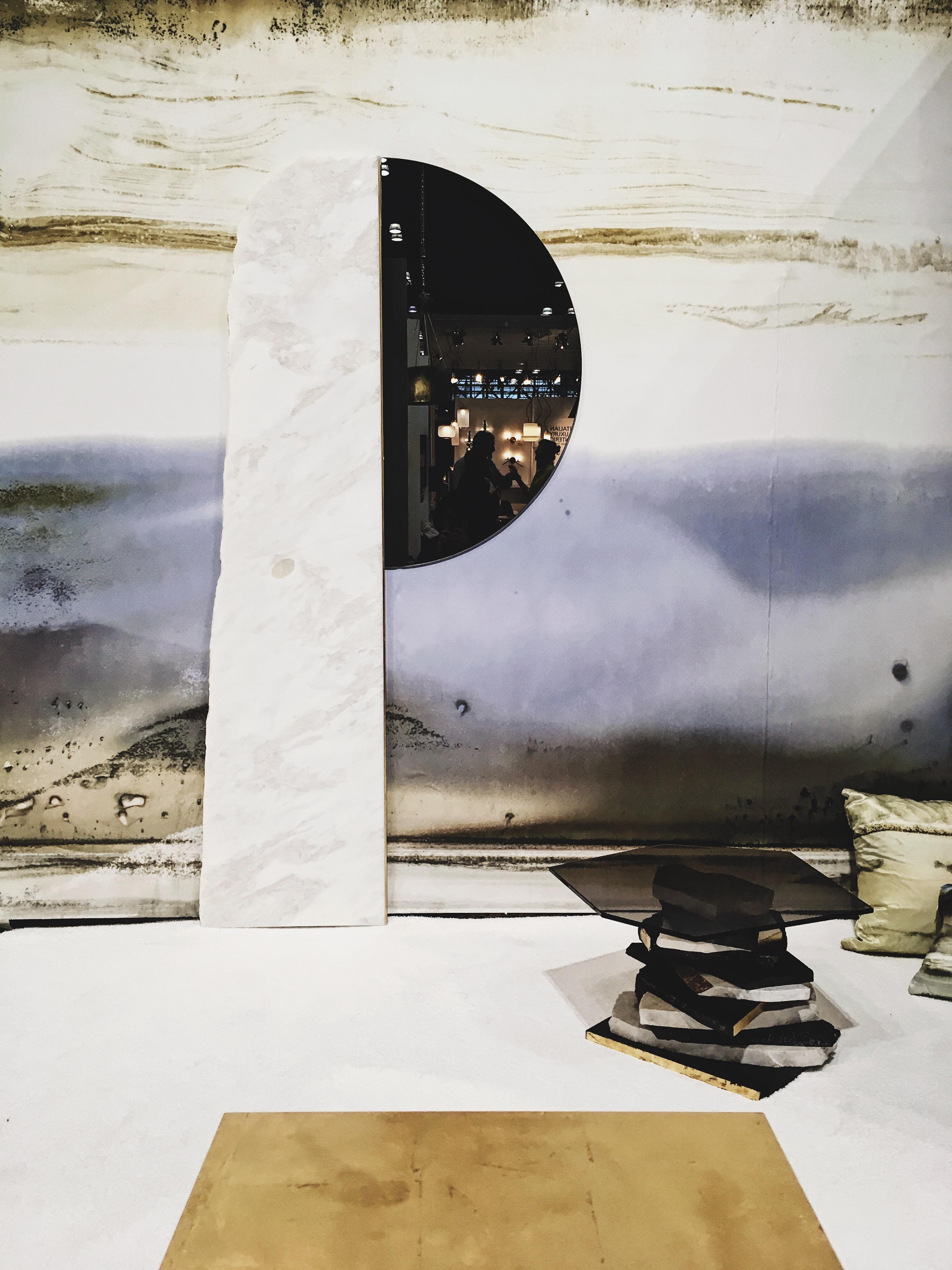 Found mirror is a minimalistic sculptural object that can serve as a centrepiece for any wall. A large slab of marble with a raw edge is juxtaposed with a half-circle tinted mirror. A thin line of polished brass in between separates marble and