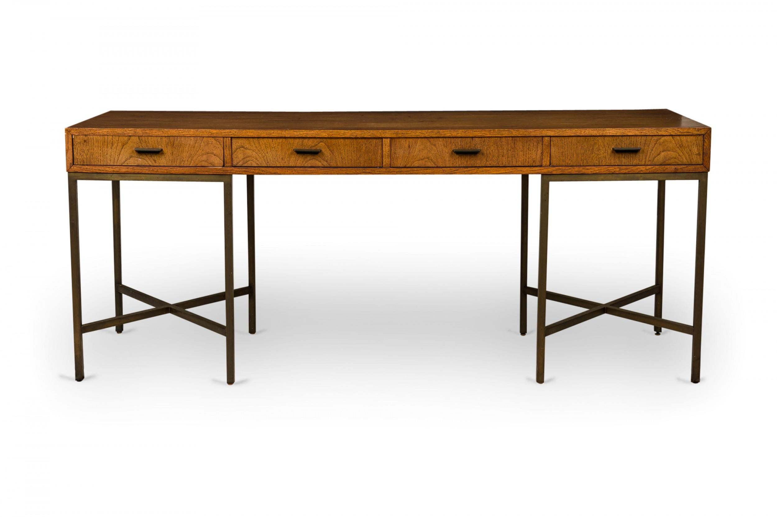 American Mid-Century desk with a rectangular walnut top containing four drawers with bronze horizontal bar drawer pulls, supported on two sets of four bronze legs on either side with independent stretcher bases. (FOUNDERS FURNITURE CO.).
 
