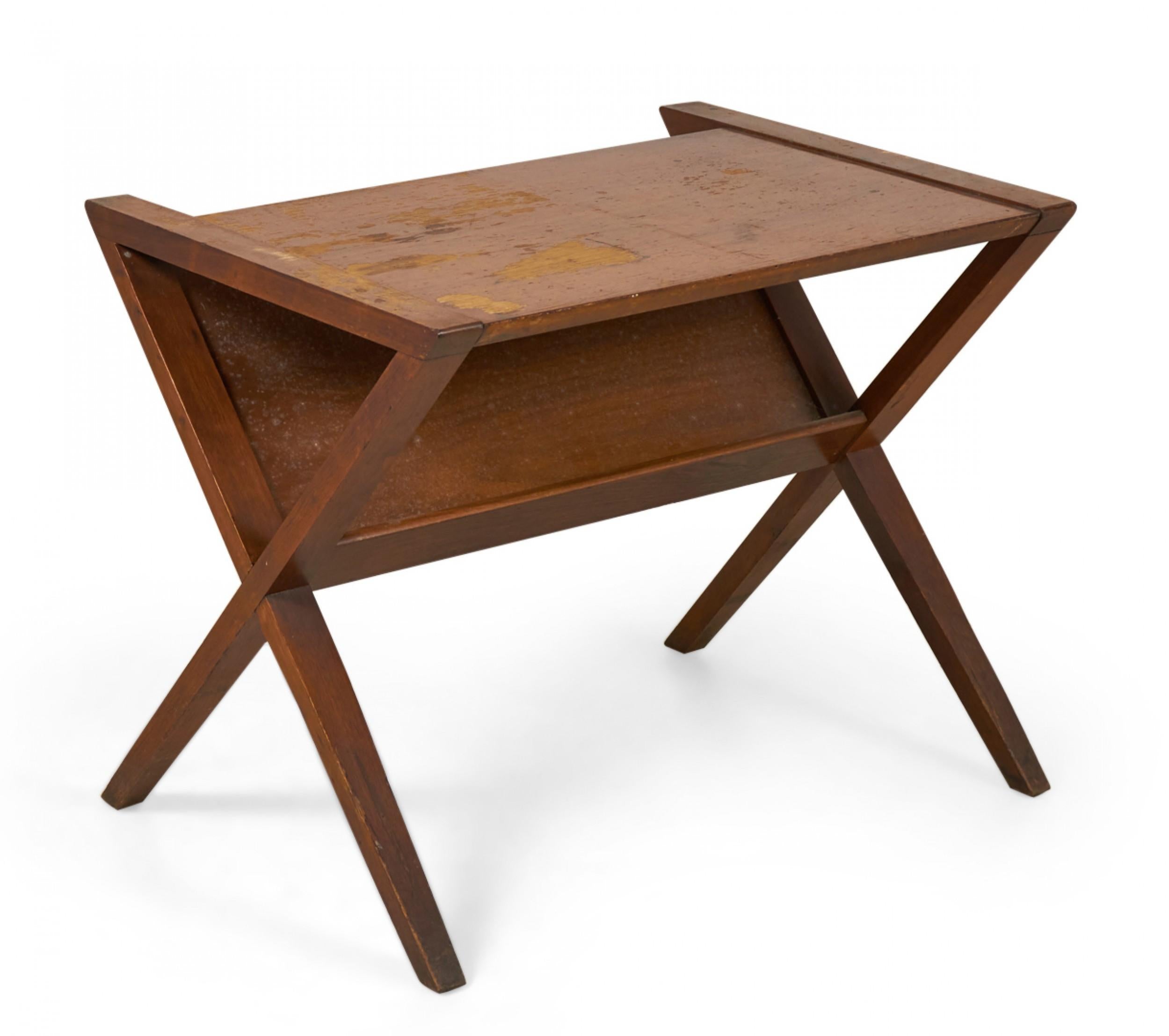 Table d'appoint / d'appoint en noyer du milieu du siècle dernier avec un plateau rectangulaire situé dans un cadre en forme de X avec une étagère à magazines intégrée en diagonale sous la surface de la table. (FONDATEURS SOCIÉTÉ DE