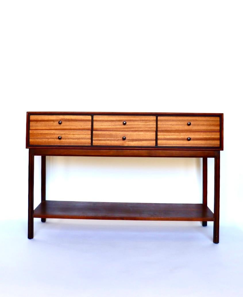 This is a charming petite sideboard designed by Jack Cartwright for Founders Patterns 9.

This beautiful piece is made of highly-figured walnut case with contracting Zebra wood drawer fronts. The distinctive black knobs contrast dramatically