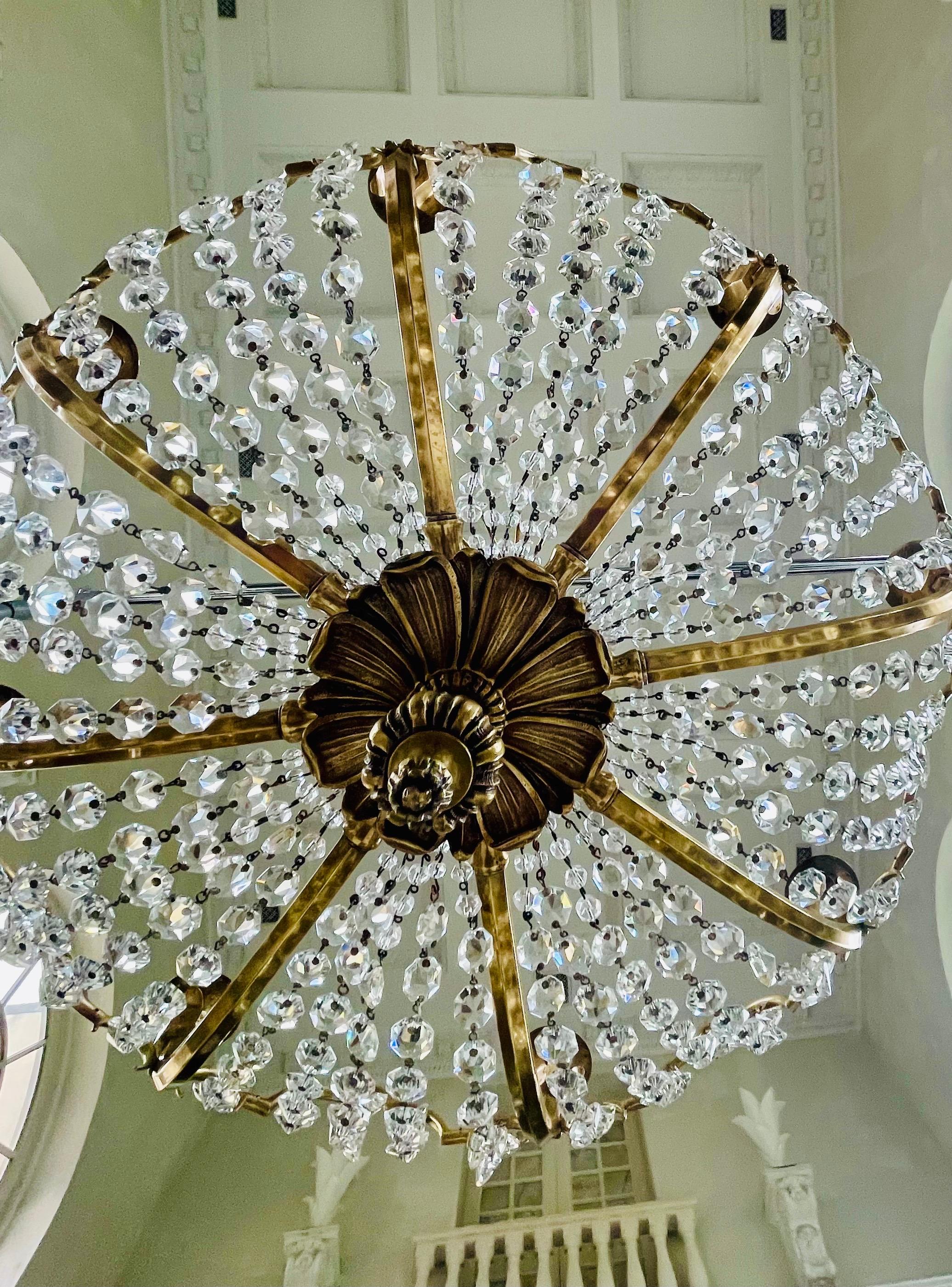 English eight arm crystal & bronze chandelier in the shape of a fountain. The frame is well built out of solid bronze. The lead cut crystal chains and prisms are of superb quality. 
We offer electrification with a one week turn around.