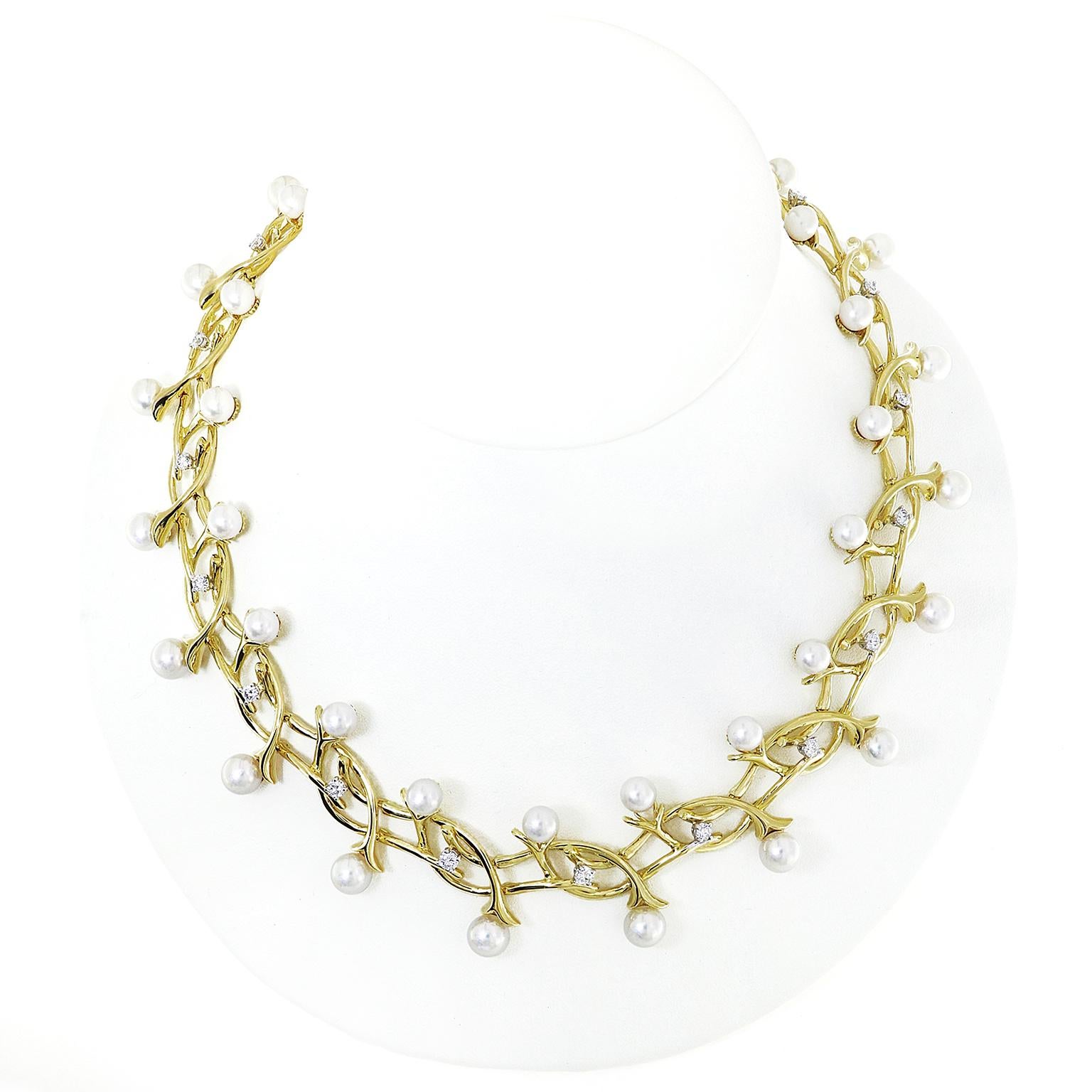 This Fountain of Dazzle necklace has a body of 18k yellow gold vines that lace throughout each other. Their tips are parted, resembling a flower sepal, which are individually adorned with pearls. Dispersed in the design are round brilliant cut