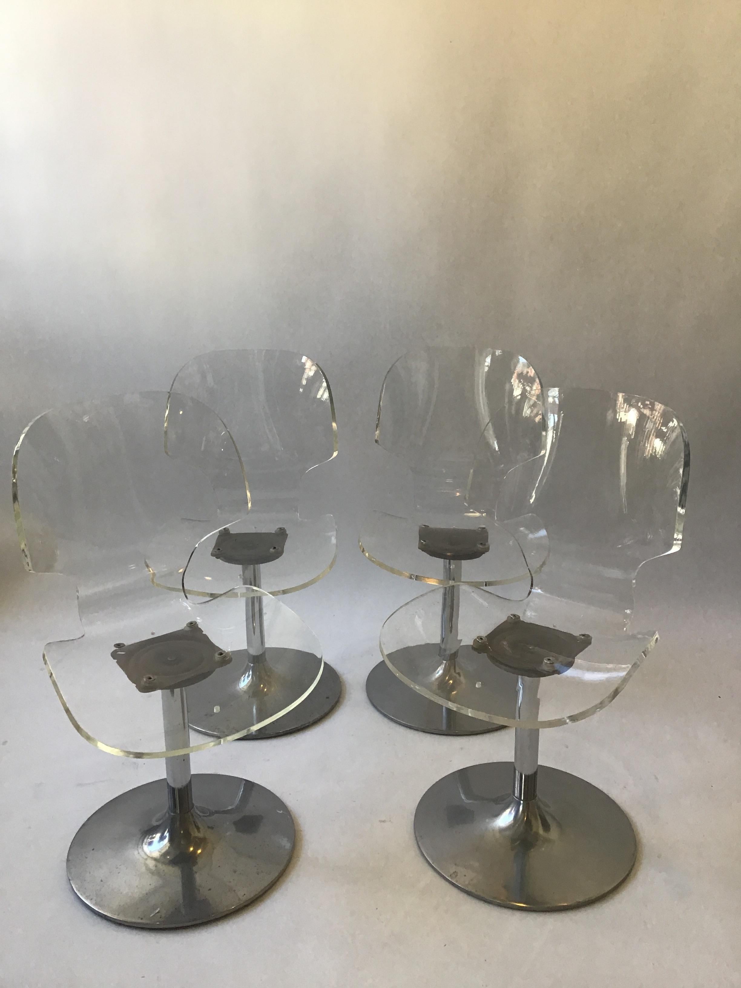 Four 1980s Lucite chairs on metal bases.