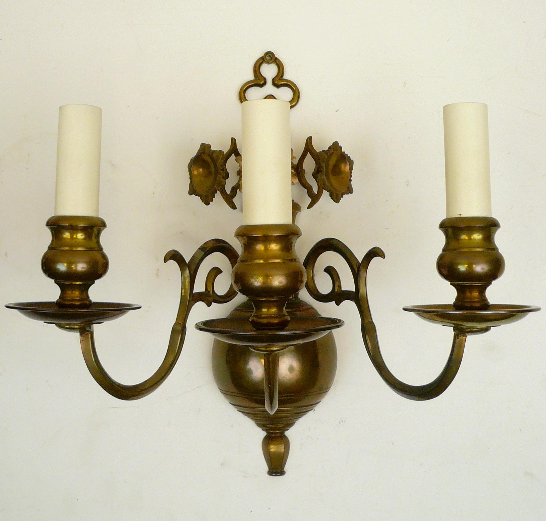 This handmade set of four 17th century Baroque style sconces have scrolled arms and floral form reflectors. They were originally purchased from Edward F. Caldwell & Company for a Tudor style Pittsburgh mansion.