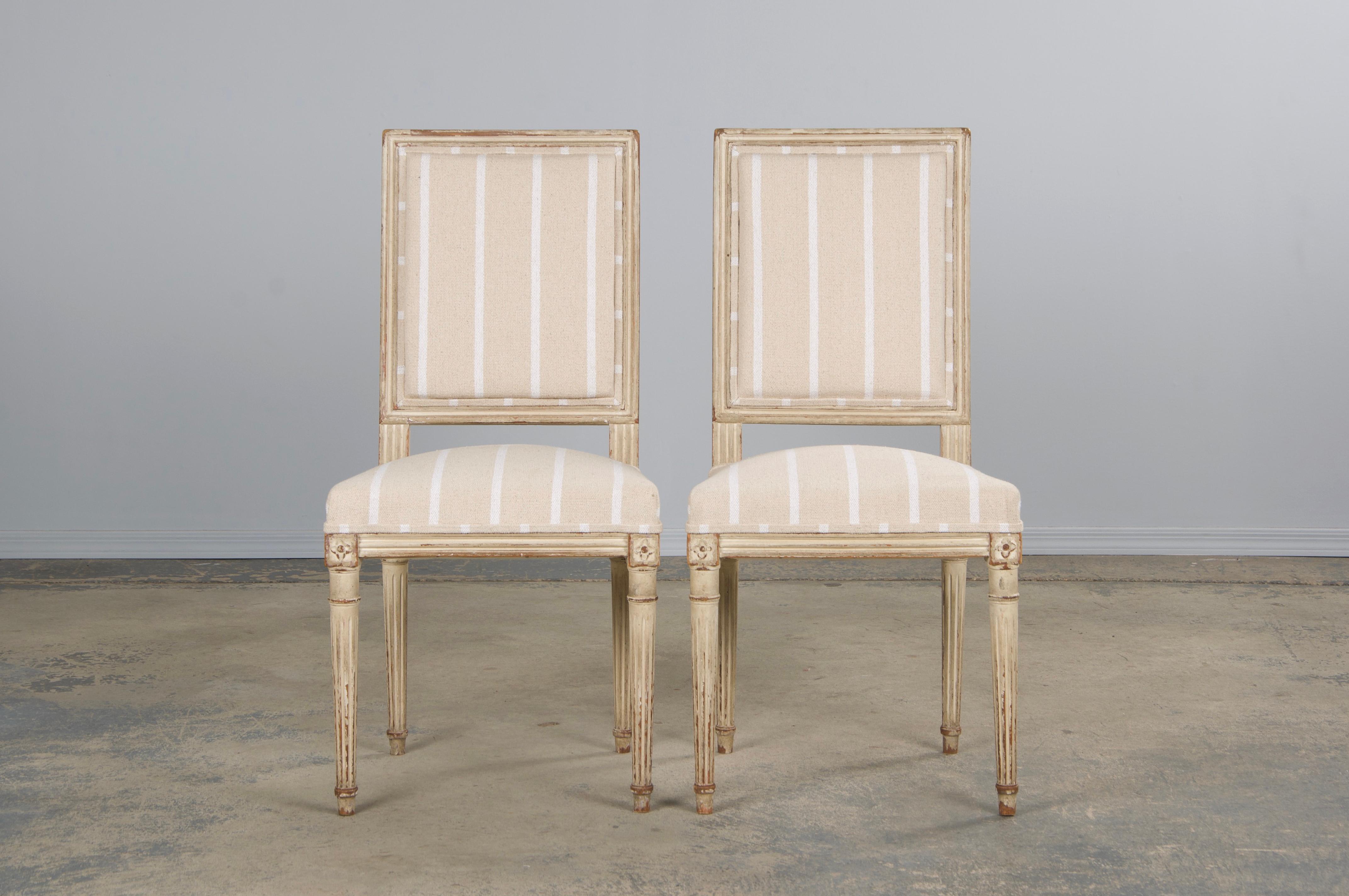 Un élégant ensemble de quatre chaises de style Louis XVI de la fin du XIXe siècle, provenant de Provence, France. Chaque chaise présente un cadre artisanal avec un dossier de forme carrée, peint à la main dans une finition blanc crème qui présente