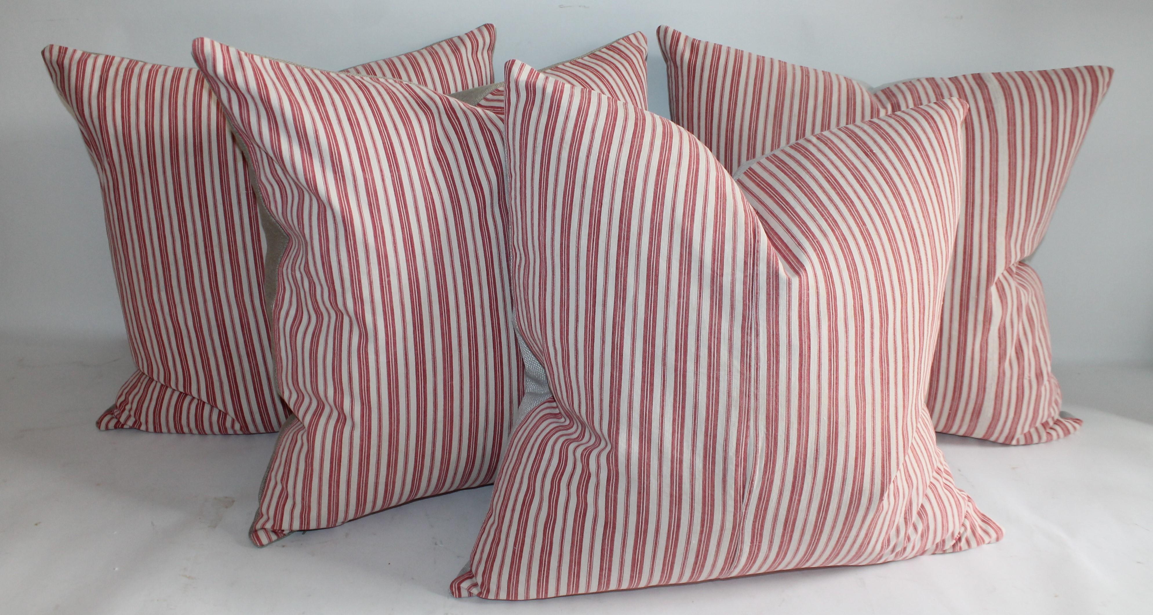 These 19th century candy stripe ticking pillows have a cream cotton linen backing. They are down and feather fill. Two pairs of pillows.
