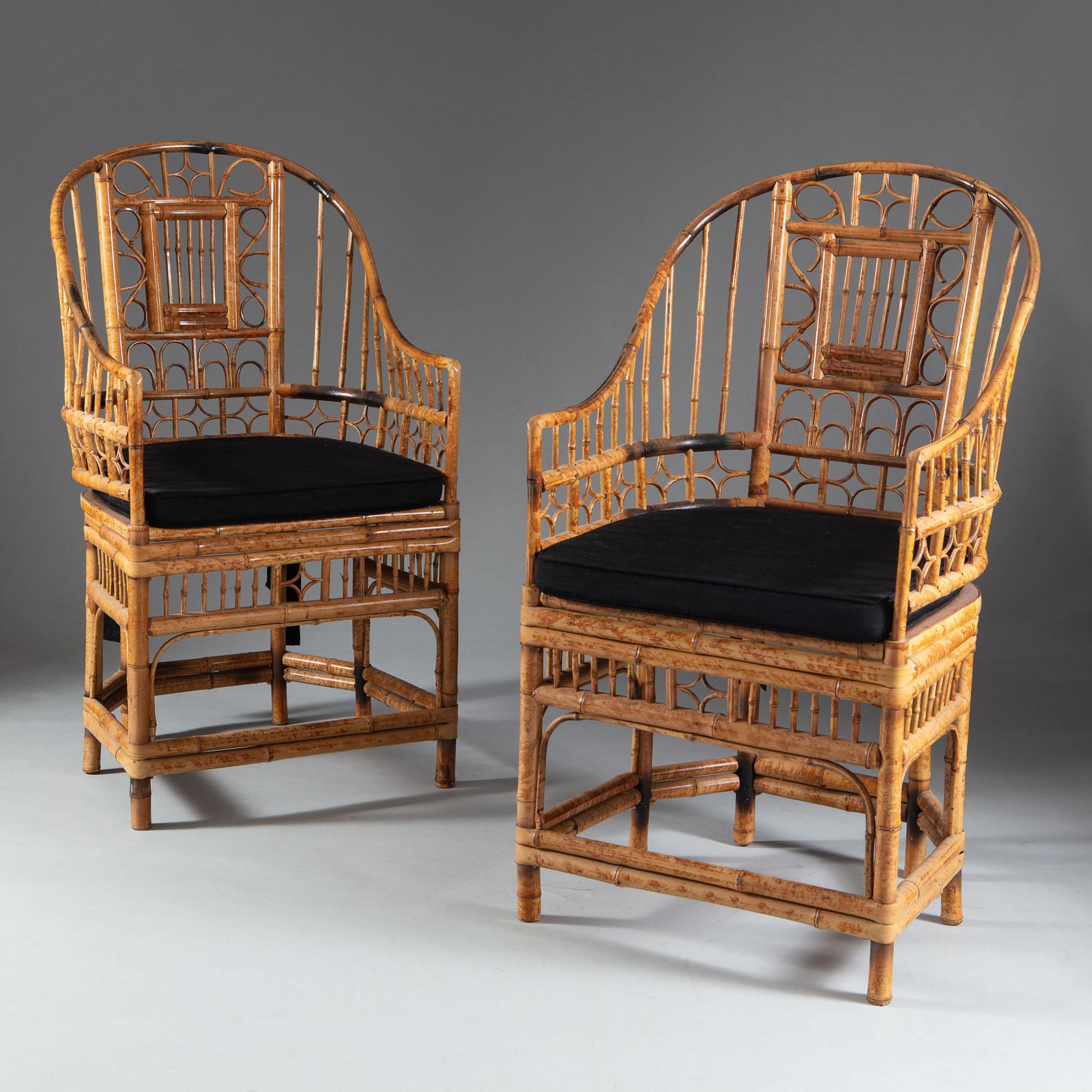 A set of four mid-20th century bamboo armchairs, the horseshoe backs with intricate scrollwork decoration, raised upon legs with conjoining stretchers. Together with squab cushion seats.

These chairs show stylistic influence of the suites of