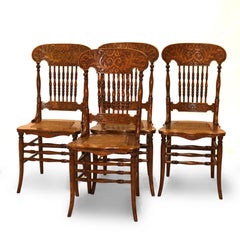 Quatre chaises anciennes en chêne pressé et à dossier en fuseau, à assise cannelée, d'époque 1910