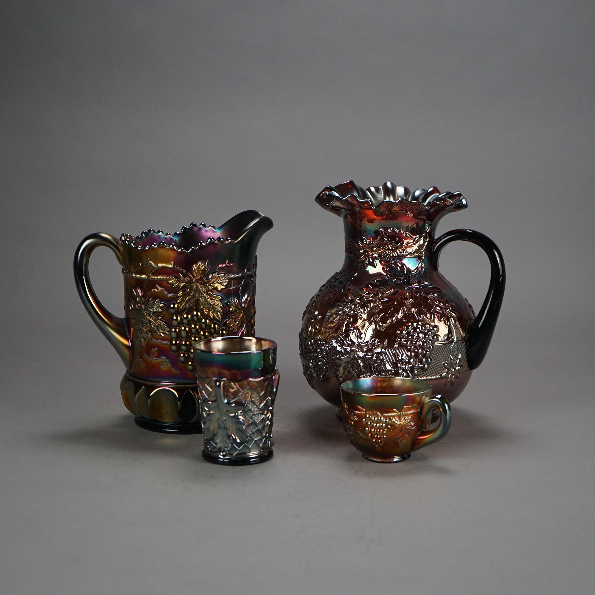 Four Piece Antique Northwood Purple Amethyst Grape & Leaf Carnival Glass Drink Set includes Two Pitchers, a Tumbler, and Handled Cup; C1920

Measures - 9