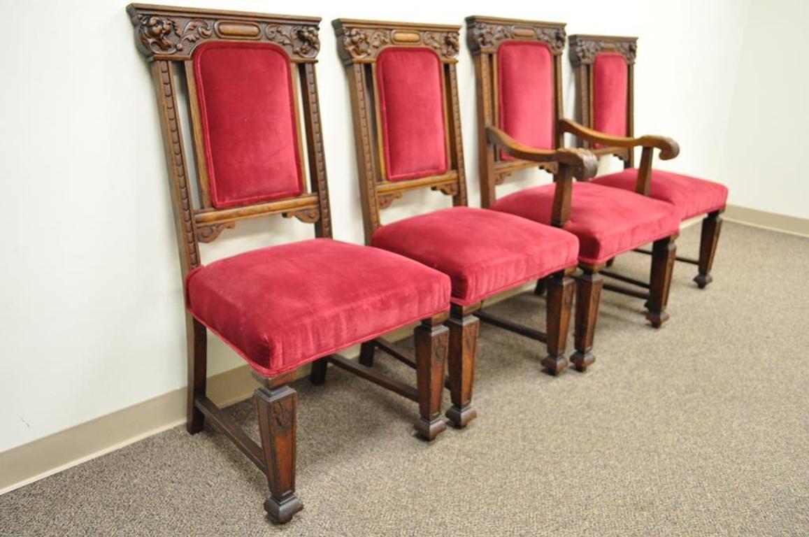 Set of four Renaissance Revival figural carved dining chairs. Item features beautifully carved solid oakwood frames, figural lion heads, and red velvet upholstery. Listing includes three side chairs and one armchair, circa 1900. Measurements: