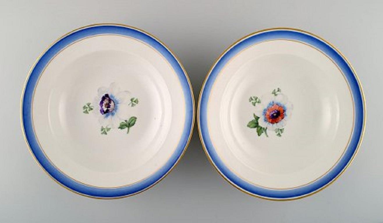 Four antique Royal Copenhagen deep plates in hand painted porcelain with flowers and blue edge with gold. Model number 592/9049, late 19th century.
Measures: 23.3 x 4.8 cm.
2nd factory quality.
In very good condition.
Stamped.