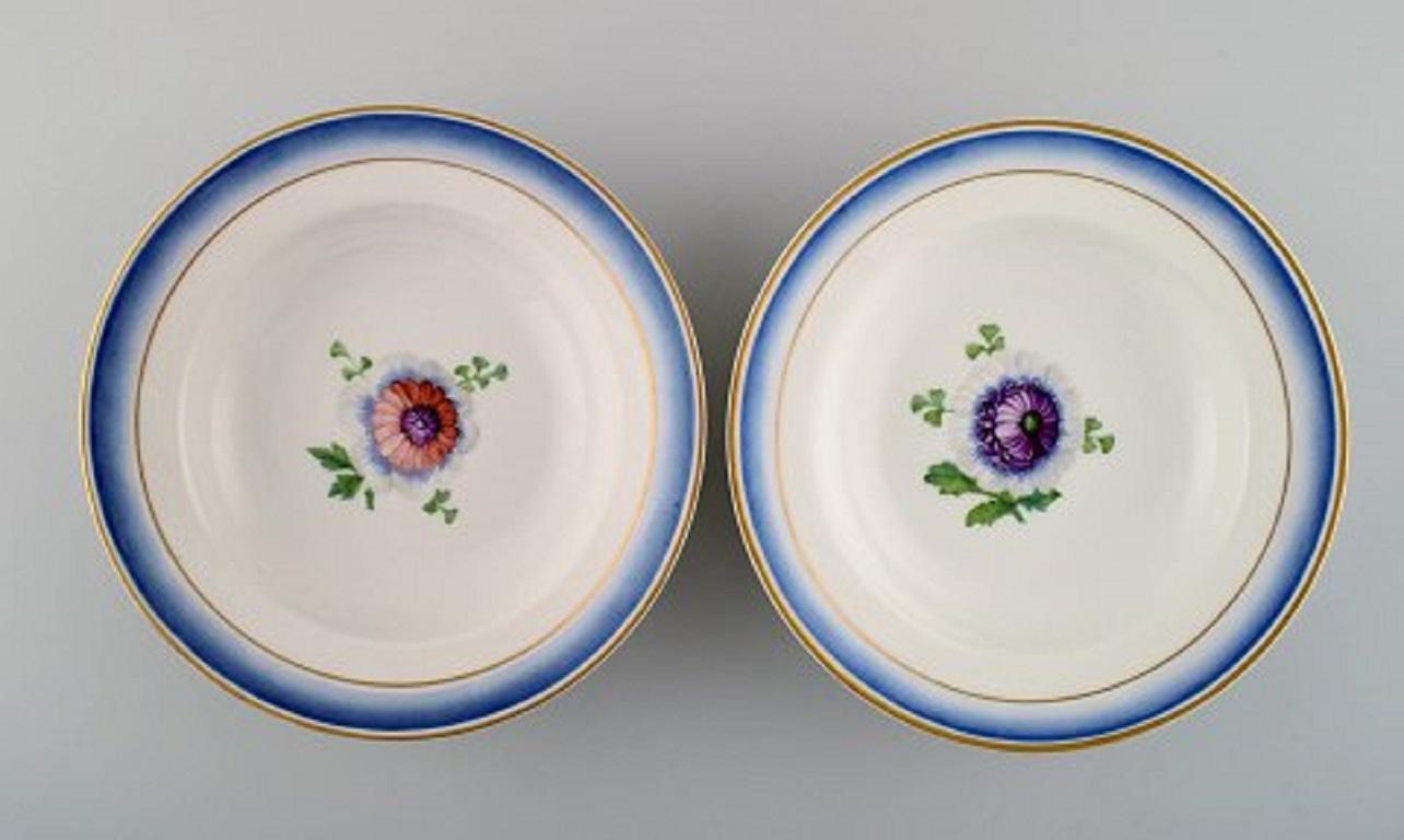 Four antique Royal Copenhagen deep plates in hand painted porcelain with flowers and blue edge with gold. Model number 592/9050, late 19th century.
Measures: 21 x 4 cm.
1st factory quality.
In very good condition.
Stamped.