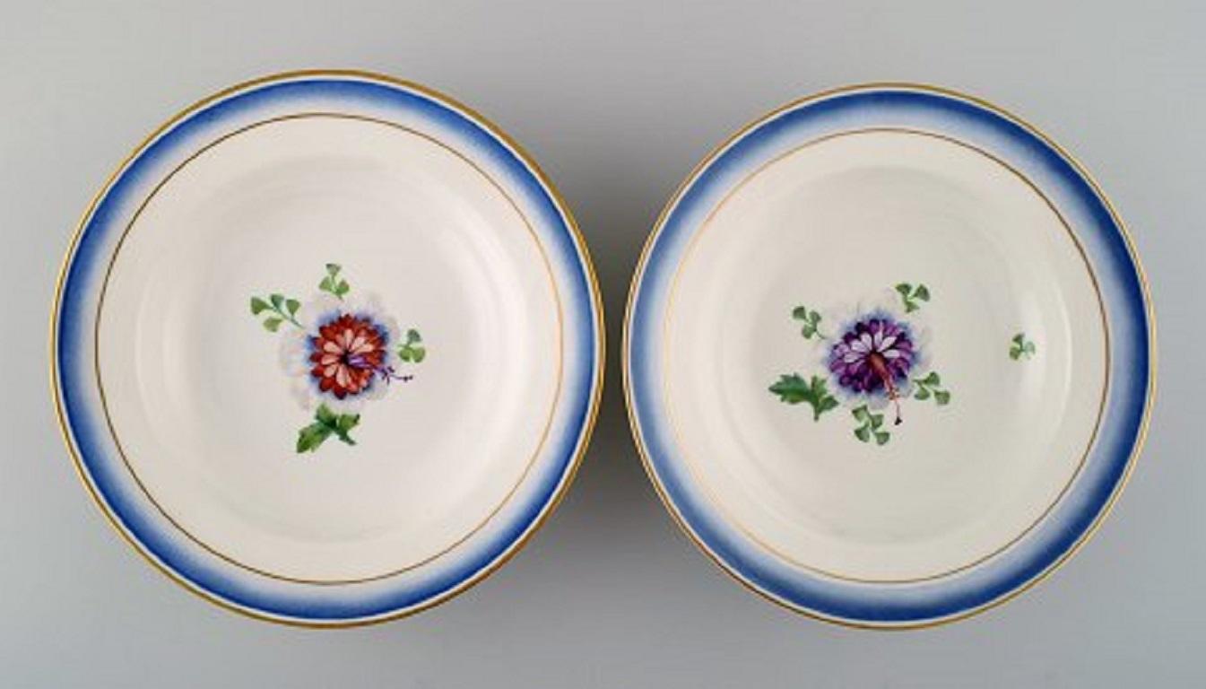 Four antique Royal Copenhagen deep plates in hand painted porcelain with flowers and blue edge with gold. Model number 592/9050, late 19th century.
Measures: 21 x 4 cm.
1st factory quality.
In very good condition.
Stamped.