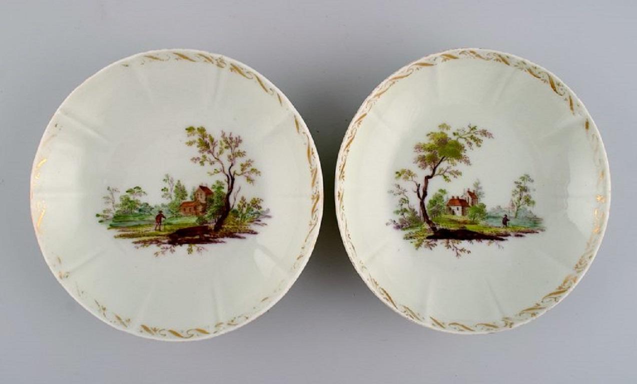 Four antique Royal Copenhagen porcelain bowls with hand-painted landscapes and gold decoration. 
Museum quality. Early 19th century.
Measures: 14.5 x 3.5 cm.
In excellent condition with no chips. Light wear in the gold.
Signed.
1st factory quality.