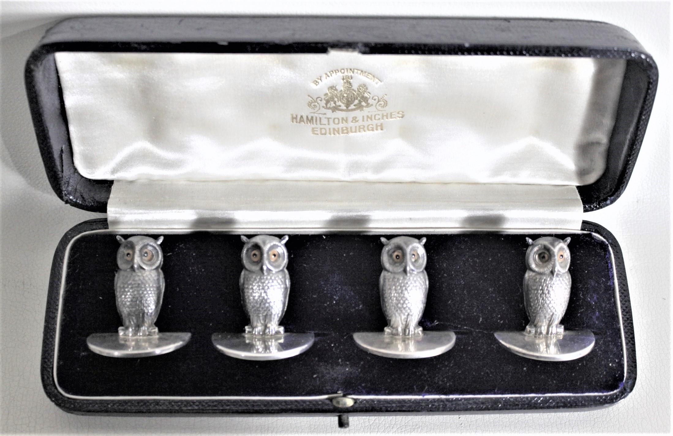 This set of four antique sterling silver place card or menu holders was made in Chester England in 1904 in the period Edwardian style. The card holders are each done as detailed figural owls with hand-painted eyes. The card holders have sturdy clips