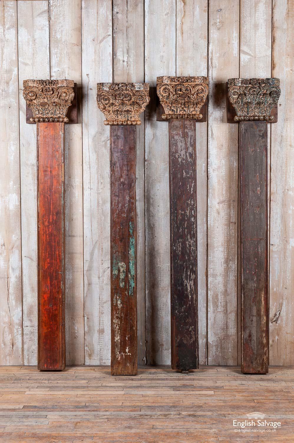A set of four antique rectangular columns in teak with beautifully hand carved decorative capitals featuring acanthus leaves, scrolls and flowers and a ball edging. One of the capitals is slightly different from the others, though it is clearly part