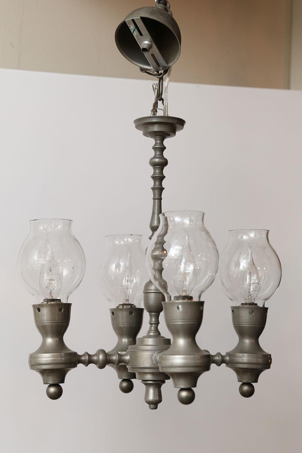 Four-arm pewter chandelier with glass shades, circa 1940. Newly wired for use within the USA. Four candelabra-size sockets. Includes chain and a canopy. The lights is a bit unusual and has a nice country or provincial feel.  I do not find this style
