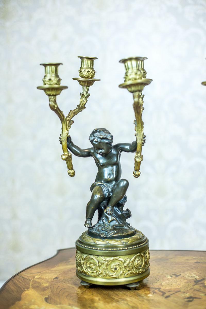 We present you these two four-arm candelabra in the Napoleon III style, circa 1840-1850. 
The putti are made of bronze, whereas some elements of brass. 

The candelabra are available on our website also as a set, together with a mantel clock,