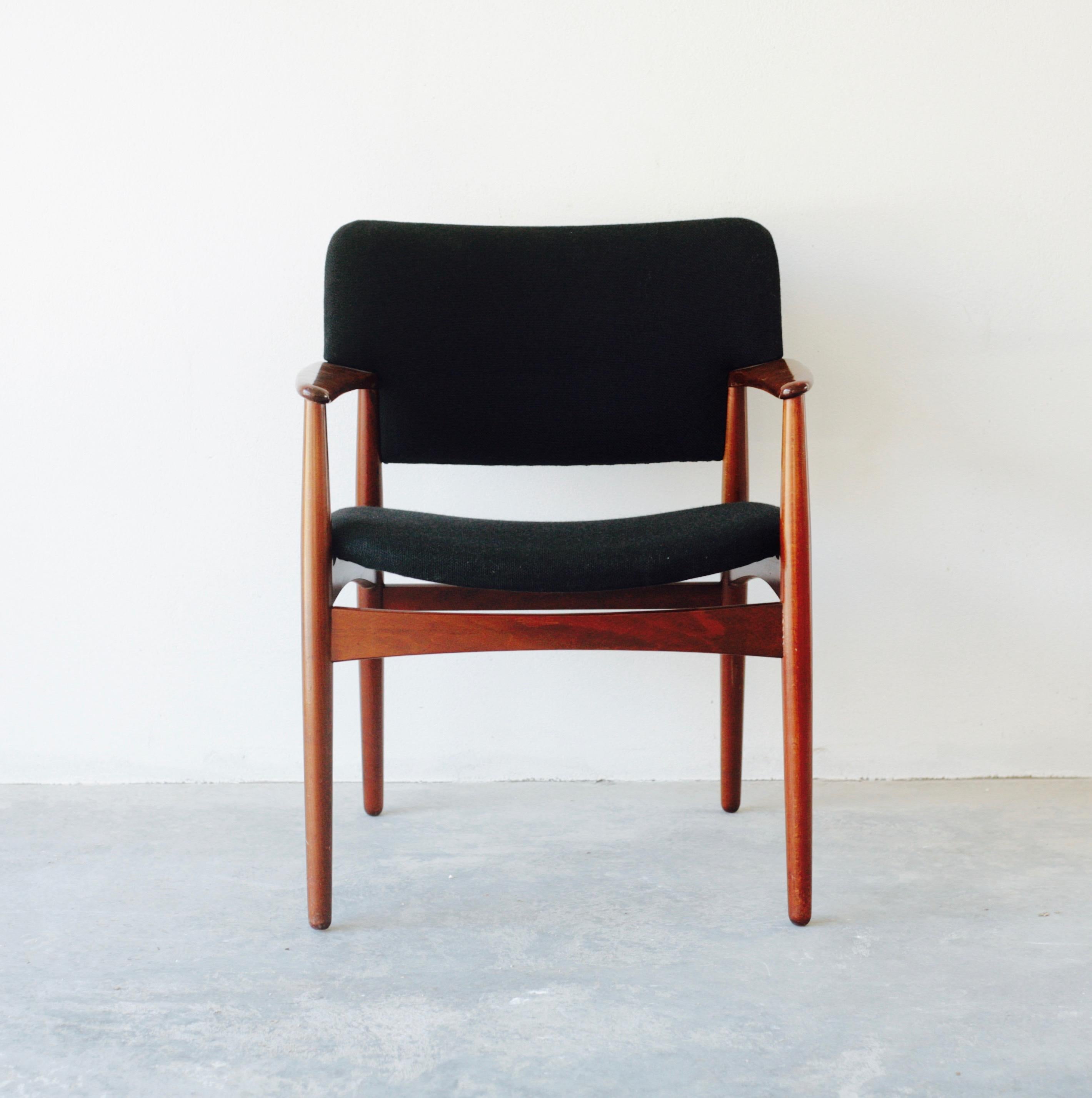 Four model 4205 dining room armchairs designed by Ejner Larsen and Aksel Bender Madsen for Fritz Hansen in the 1950s. Seats covered with black wool upholstery. Chair made of stained beech.