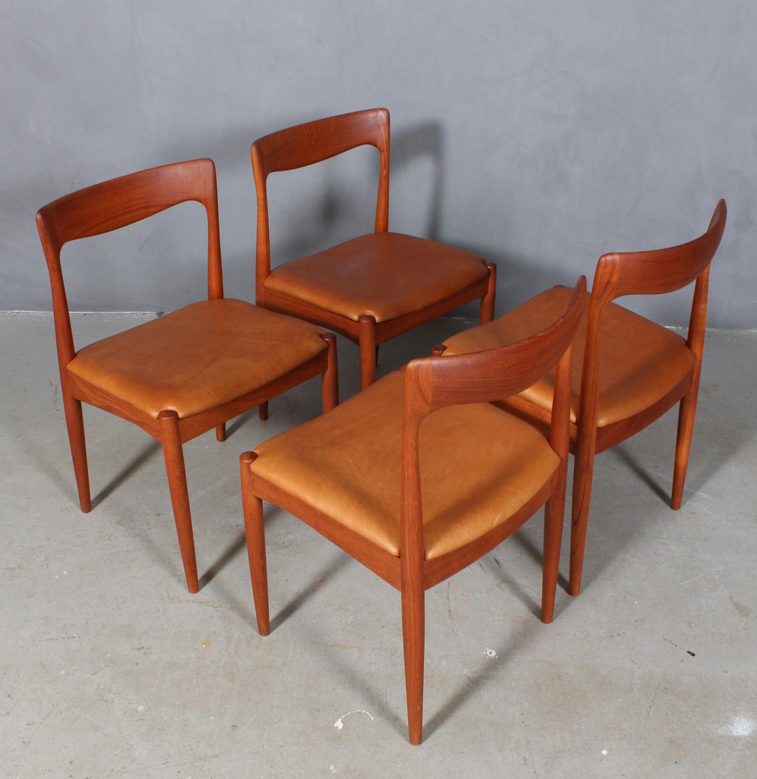 Set of four Arne Vodder dining chairs in solid teak.

New upholstered seats with tan aniline leather.

Made by Vamo.