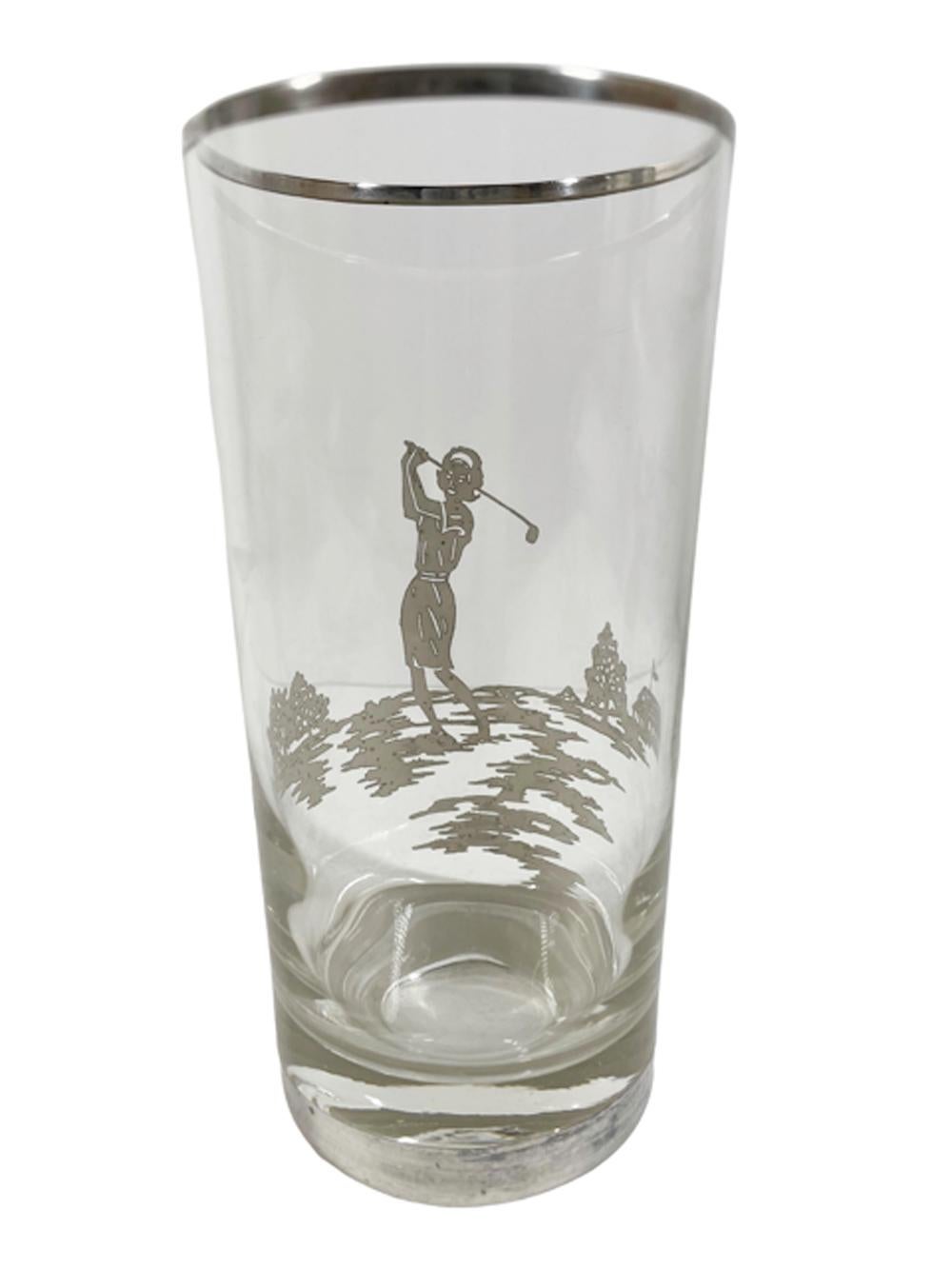 Four Art Deco silver overlay highball glasses with a female golfer on a golf course with the clubhouse in the background.