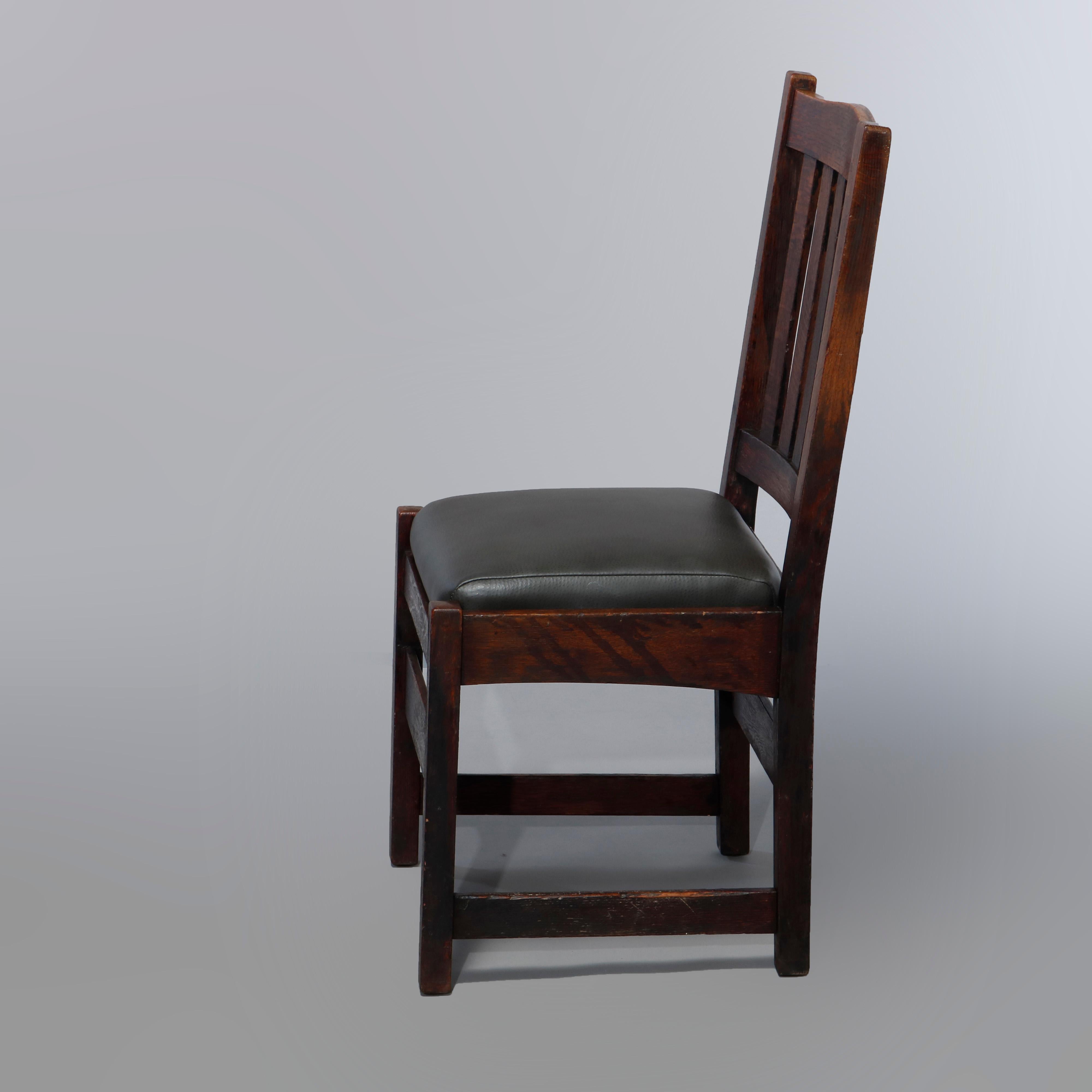 An antique Arts & Crafts set of four dining chairs by L & J G Stickley offer oak construction with slat backs over newly upholstered leather seats and raised on square and straight legs, signed, C1910

Measures: 38.25