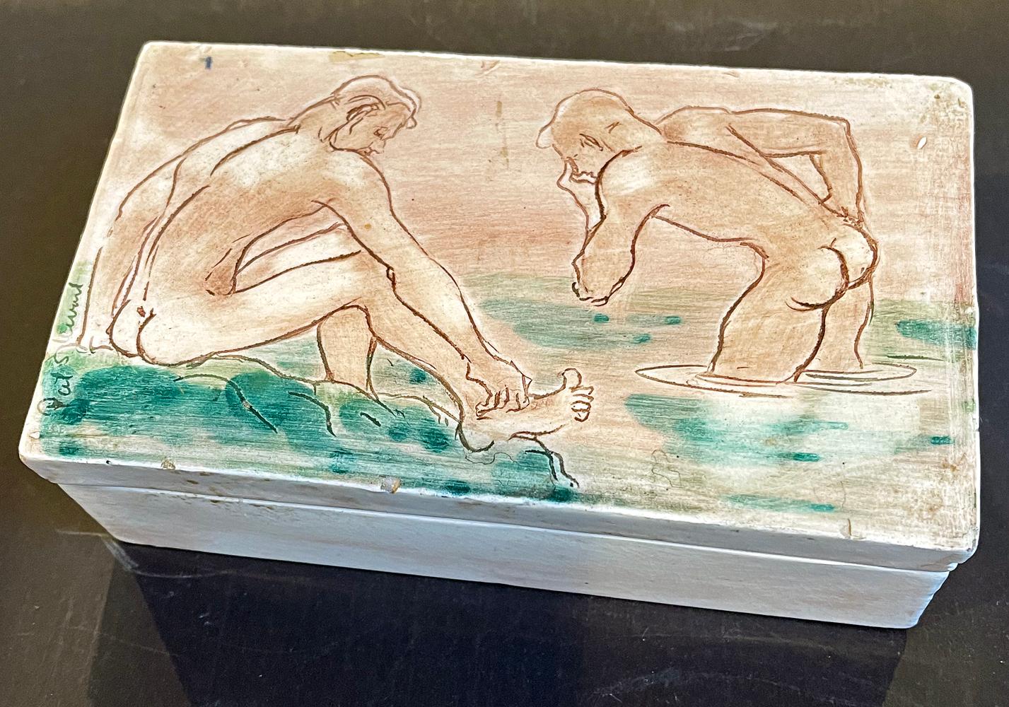 Extremely rare and memorable, this ceramic box features two male nude figures on its cover and two others inside, all shown sitting, walking and bathing along the rocky shore of Laguna Beach, California. The figures are shown in sandy, pale brown