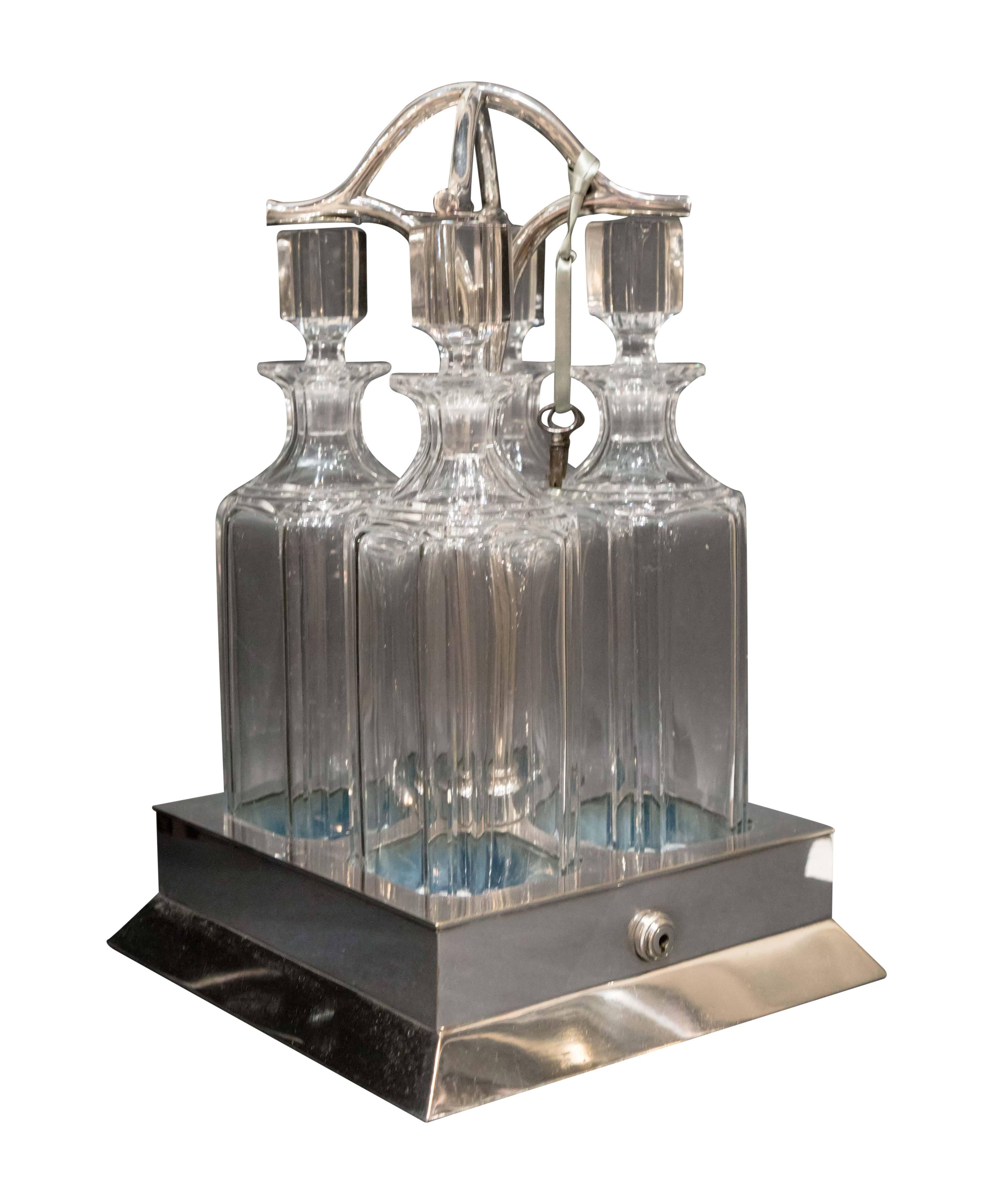 Four bottle locking tanalus with silver plate, circa 1890. Crystal cut-glass and sterling plated base. This adds a level of sophistication to any display case!