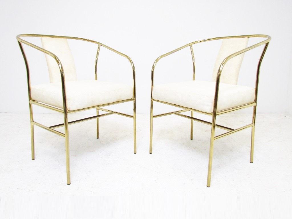 Set of four classic Hollywood Regency style armchairs by Milo Baughman for Thayer Coggin. The chairs have brass tube frames. Seats and backs upholstered in white. These can be used as lounge chairs as well as dining chairs.