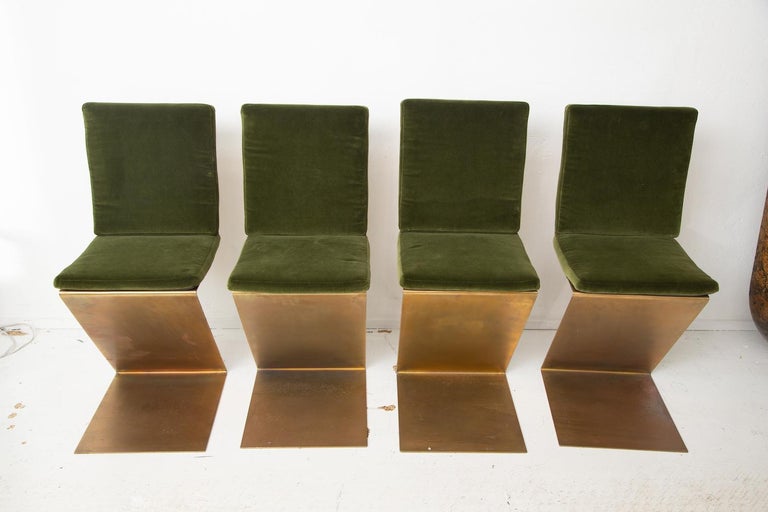 Based on the original 1934 design in wood by Gerrit Rietveld, these brass plated steel zig zag chairs sizzle thanks to green velvet cushions and chair backs custom-corseted in sexy black harness leather.