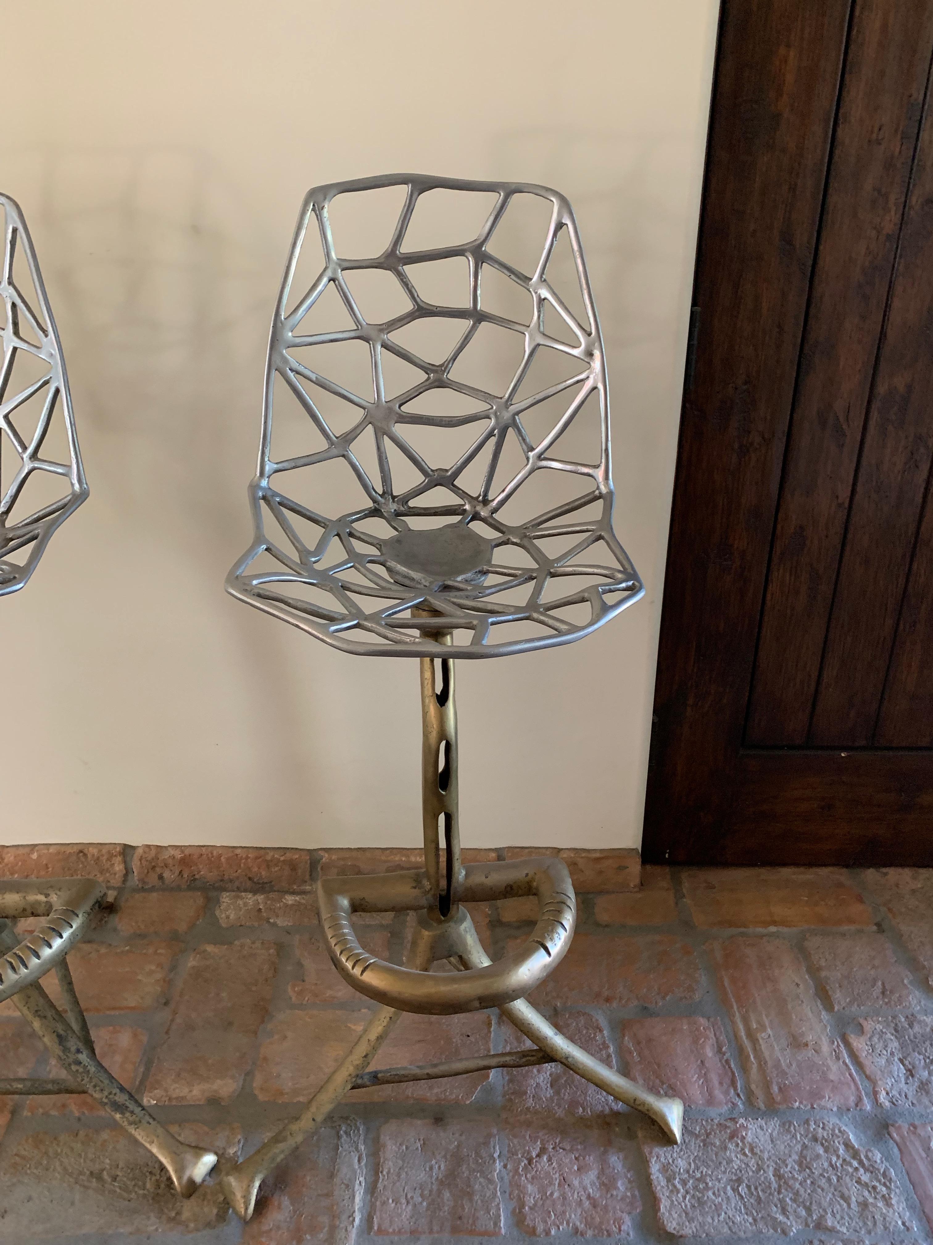 Available are four one-of-a-kind barstools. Custom made pieces of art, they are uniquely designed with a unique bronze base and artistically designed seat and back of aluminum. The four were acquired from a Gentleman's Club in Barcelona. While they