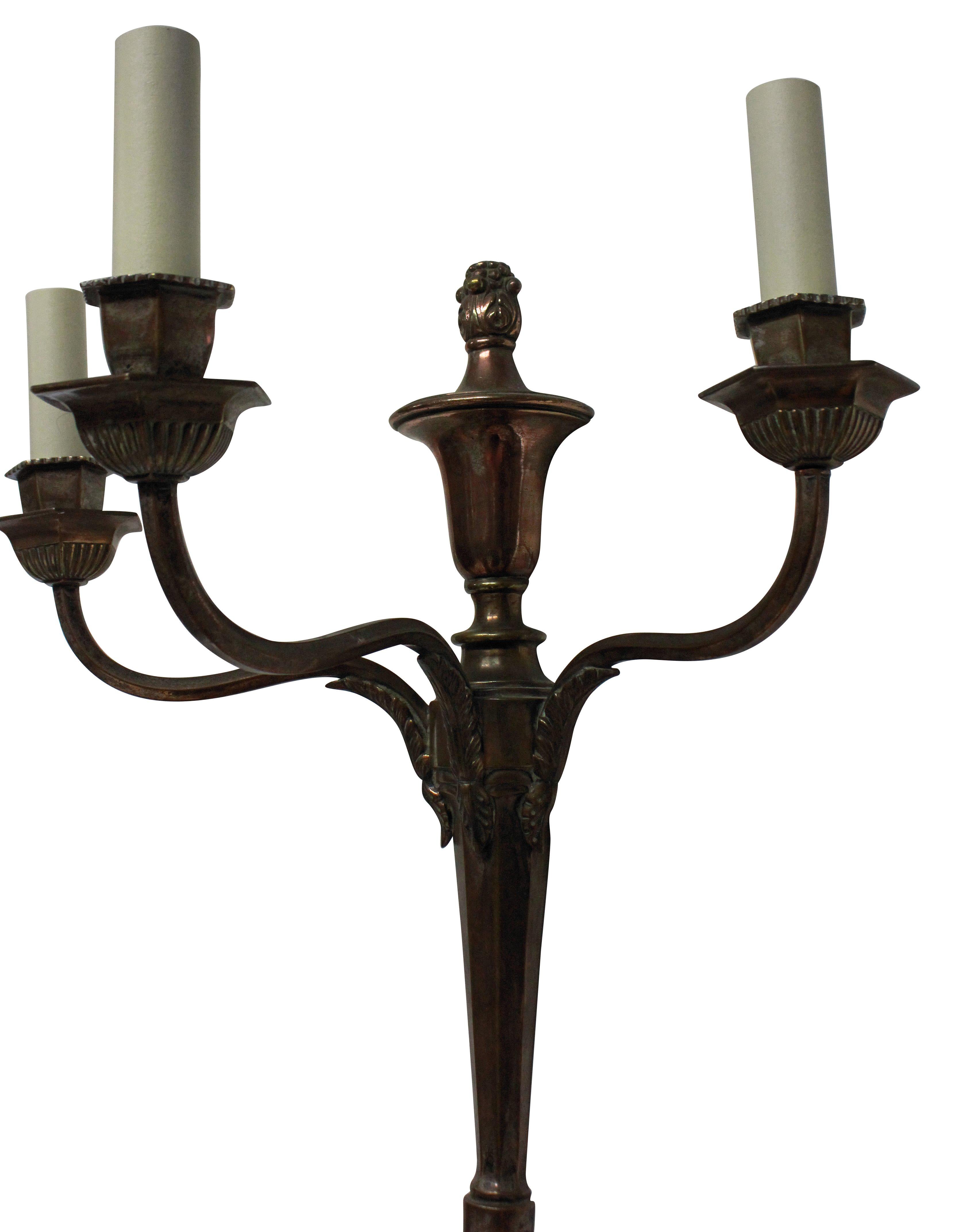 A set of four English neoclassical three-branch wall sconces in an un-restored bronzed finish.