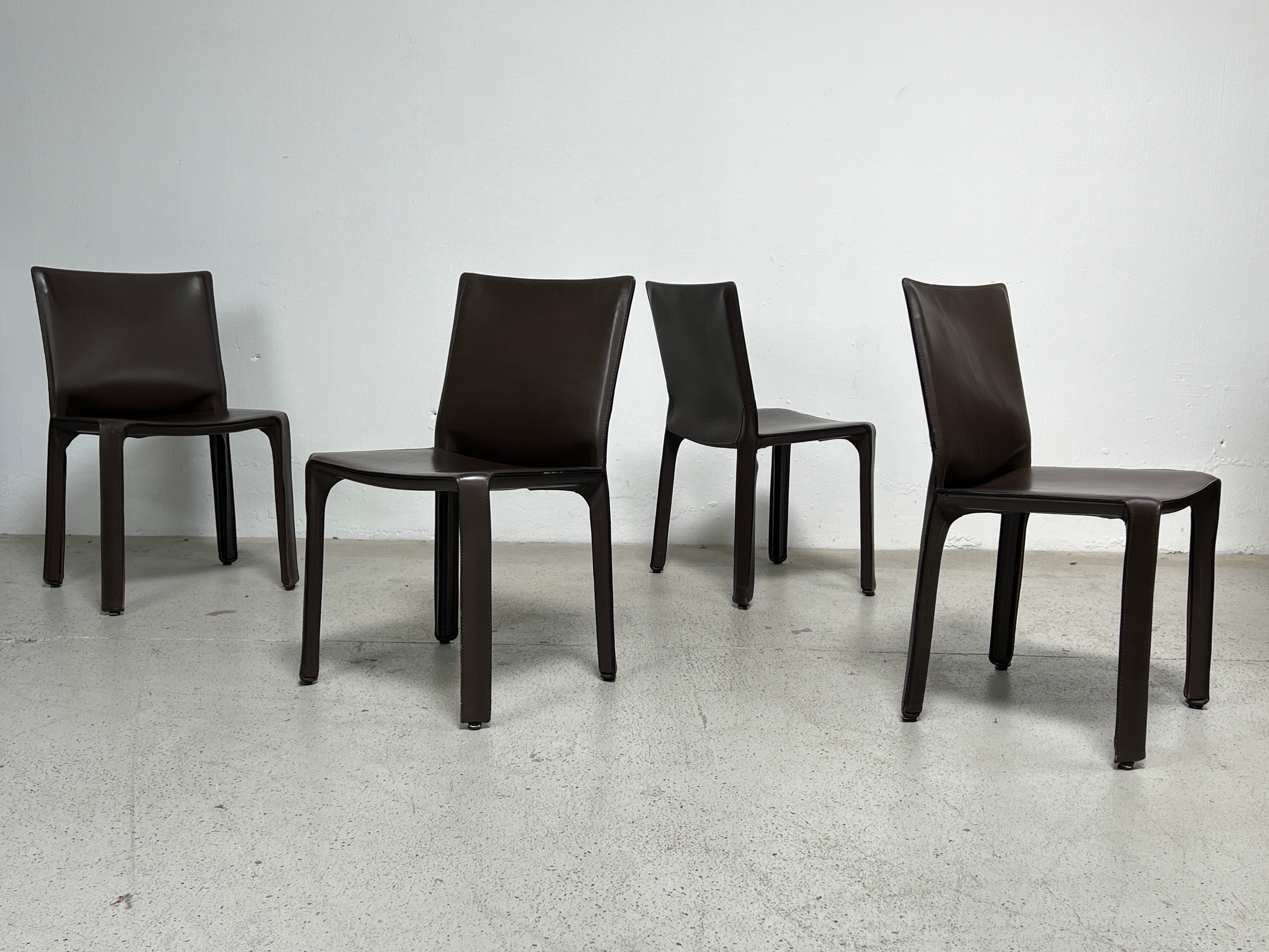 A set of four brown leather cab chairs designed by Mario Bellini for Cassina. 